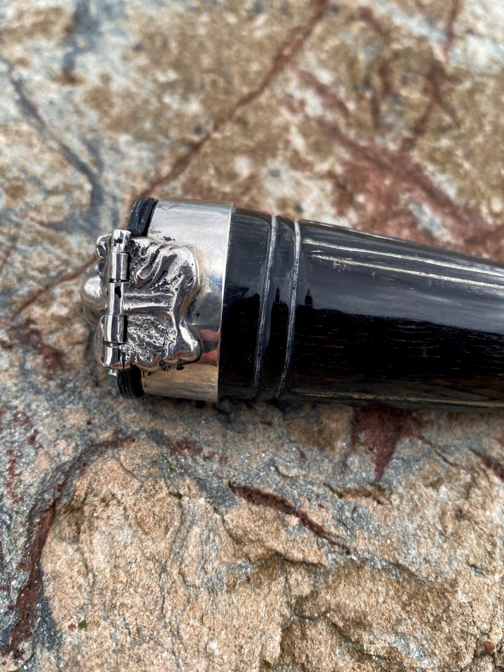 A 19th-century dark carved horn snuff mull featuring a sterling silver rim collar and a silver lid hinged with an allegorical face relief. View V