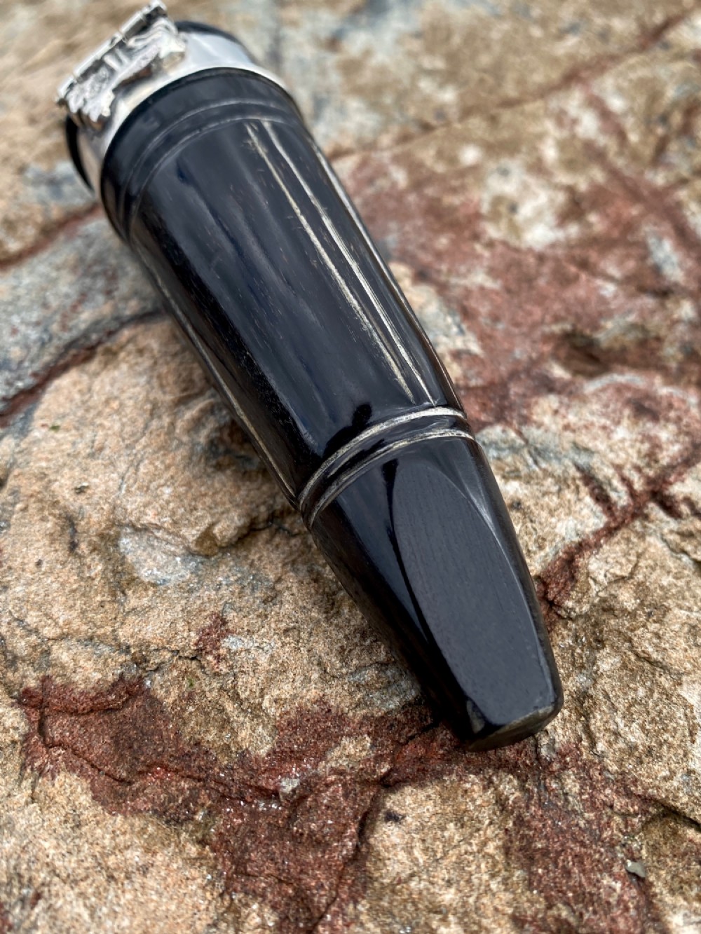 A 19th-century dark carved horn snuff mull featuring a sterling silver rim collar and a silver lid hinged with an allegorical face relief. View VII