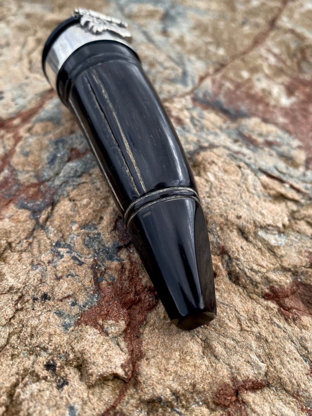 A 19th-century dark carved horn snuff mull featuring a sterling silver rim collar and a silver lid hinged with an allegorical face relief. View VIII