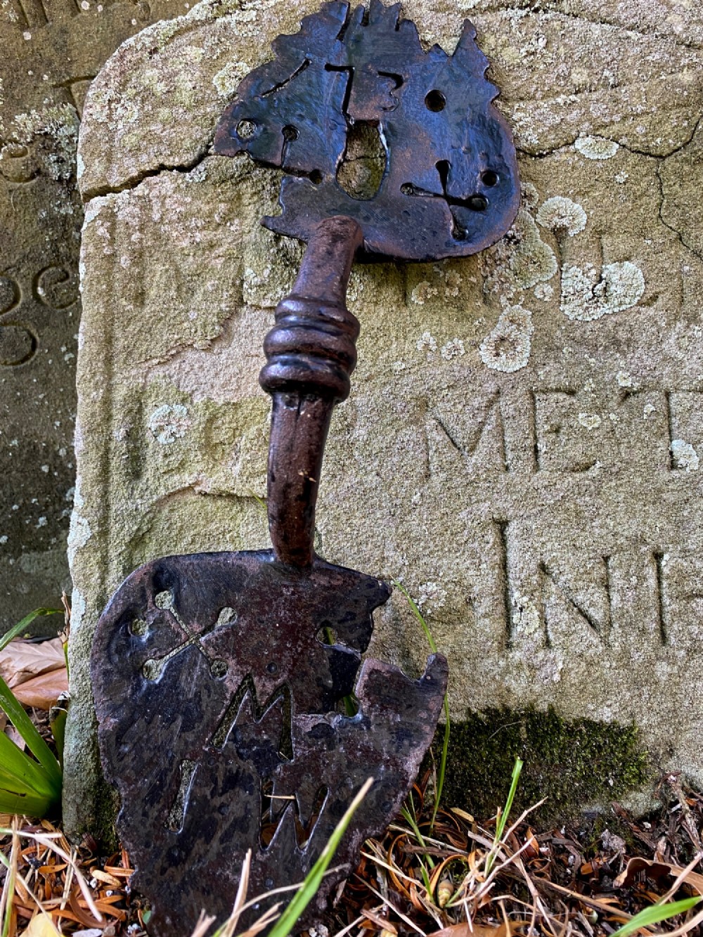 An 18th-century hand-forged wrought iron door handle featuring pierced decorative motifs, stamped initials, and the date 1730.