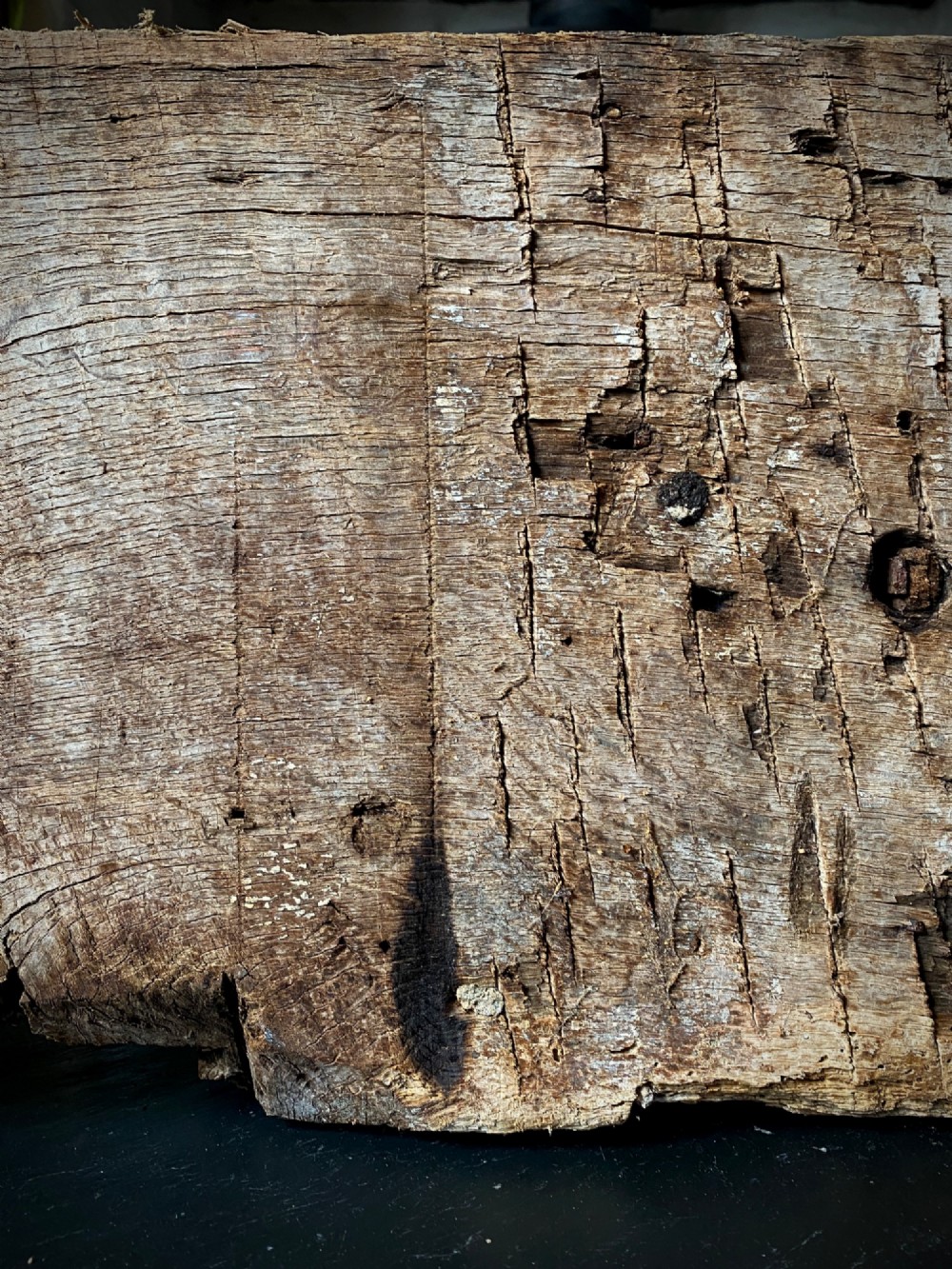A thick section of hand-hewn solid oak timber displaying natural wood grain, fissures, and surface burn markings. View II