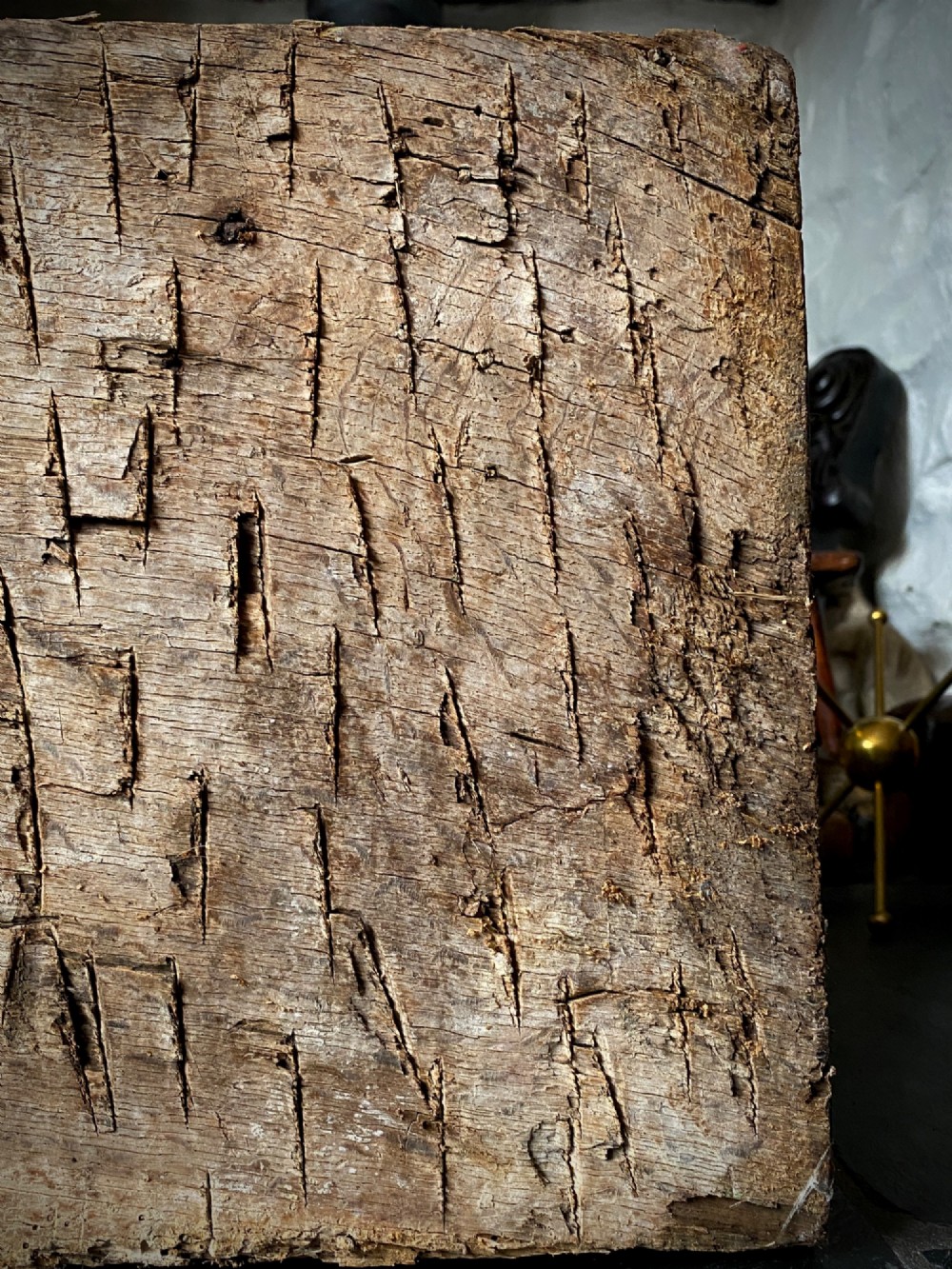 A thick section of hand-hewn solid oak timber displaying natural wood grain, fissures, and surface burn markings. View VII