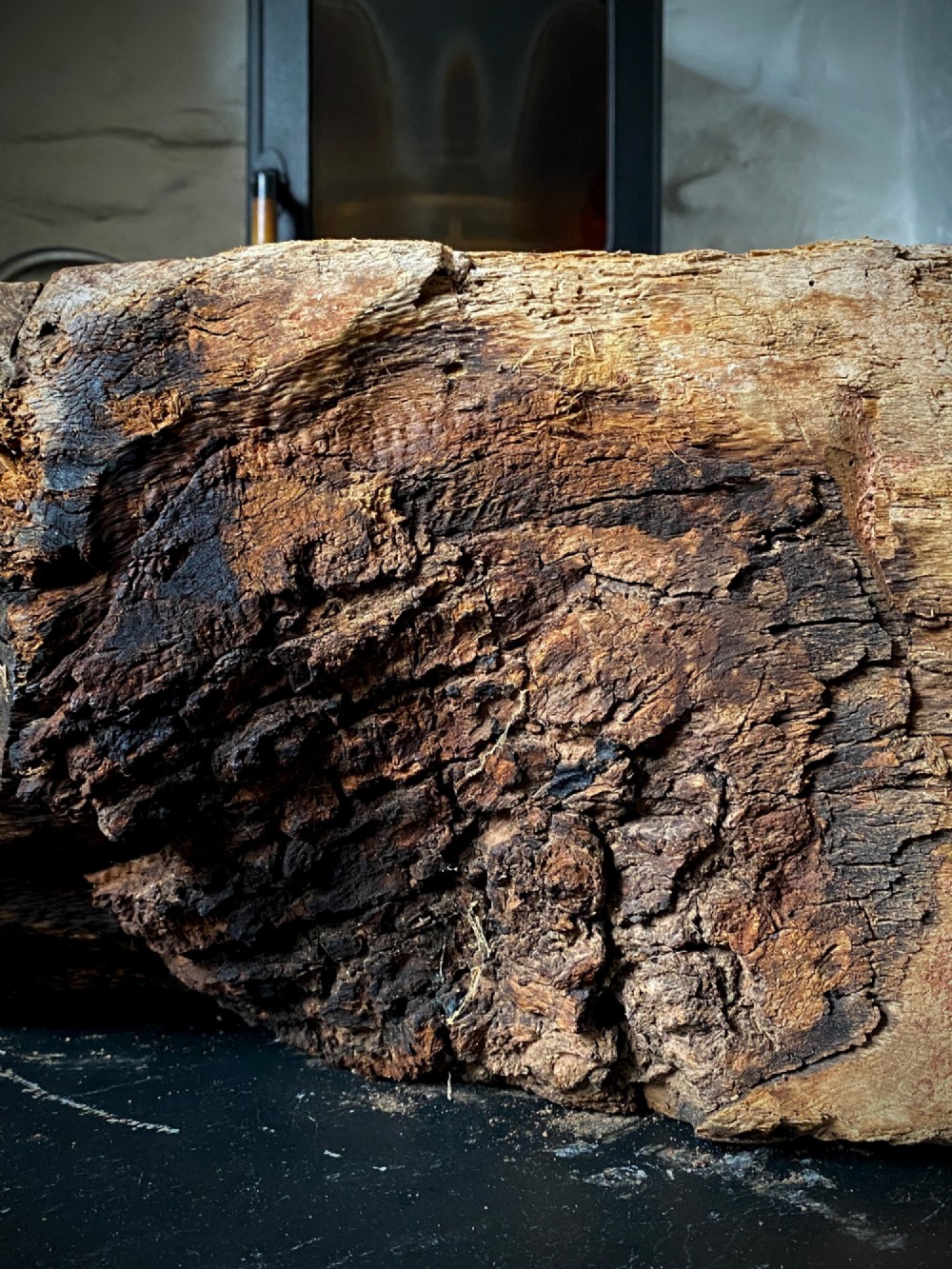 A thick section of hand-hewn solid oak timber displaying natural wood grain, fissures, and surface burn markings. View XI