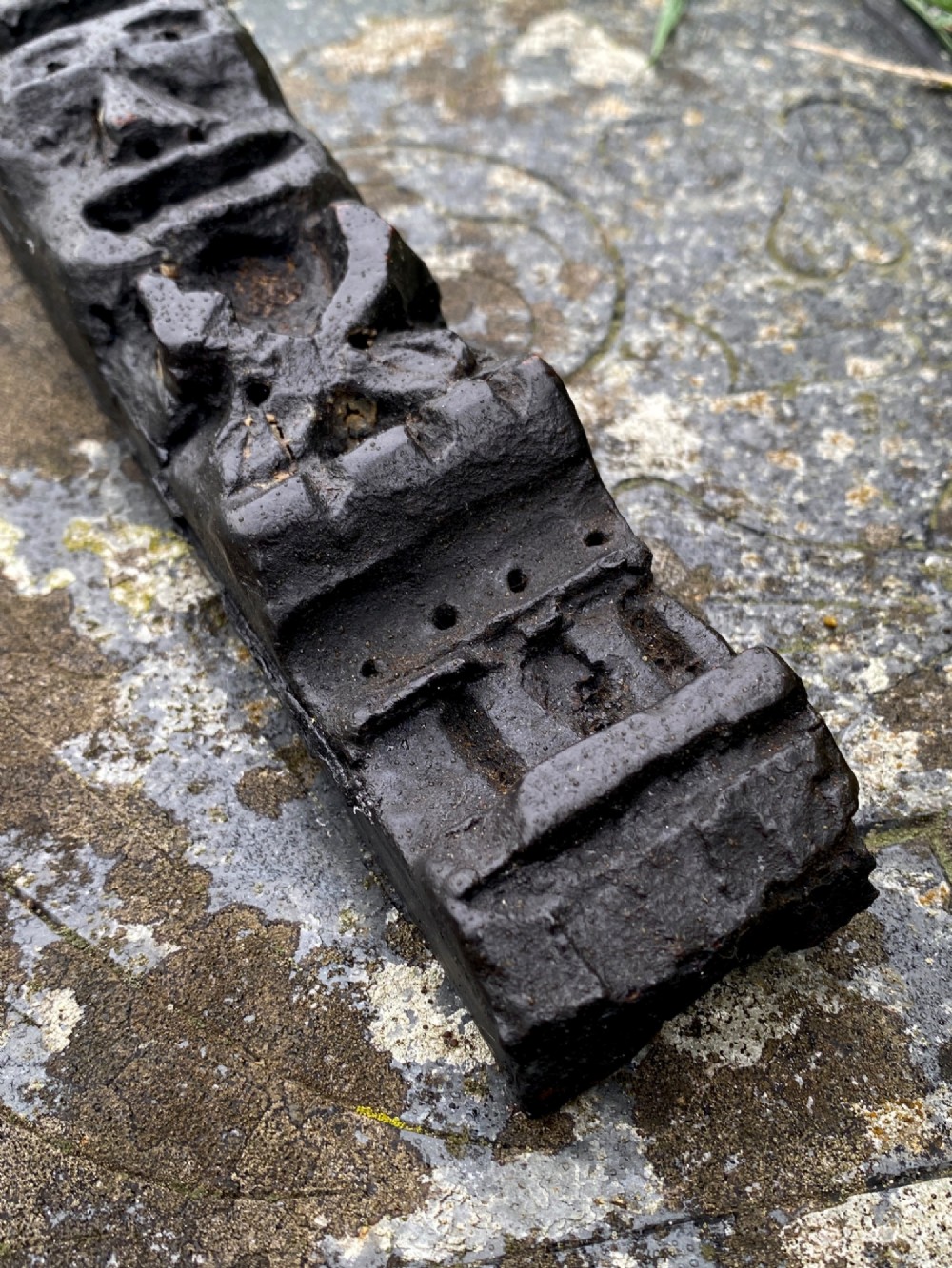 A vertical dark oak wood carving depicting a stylised human face and figure with hand-chiselled detailing. View III