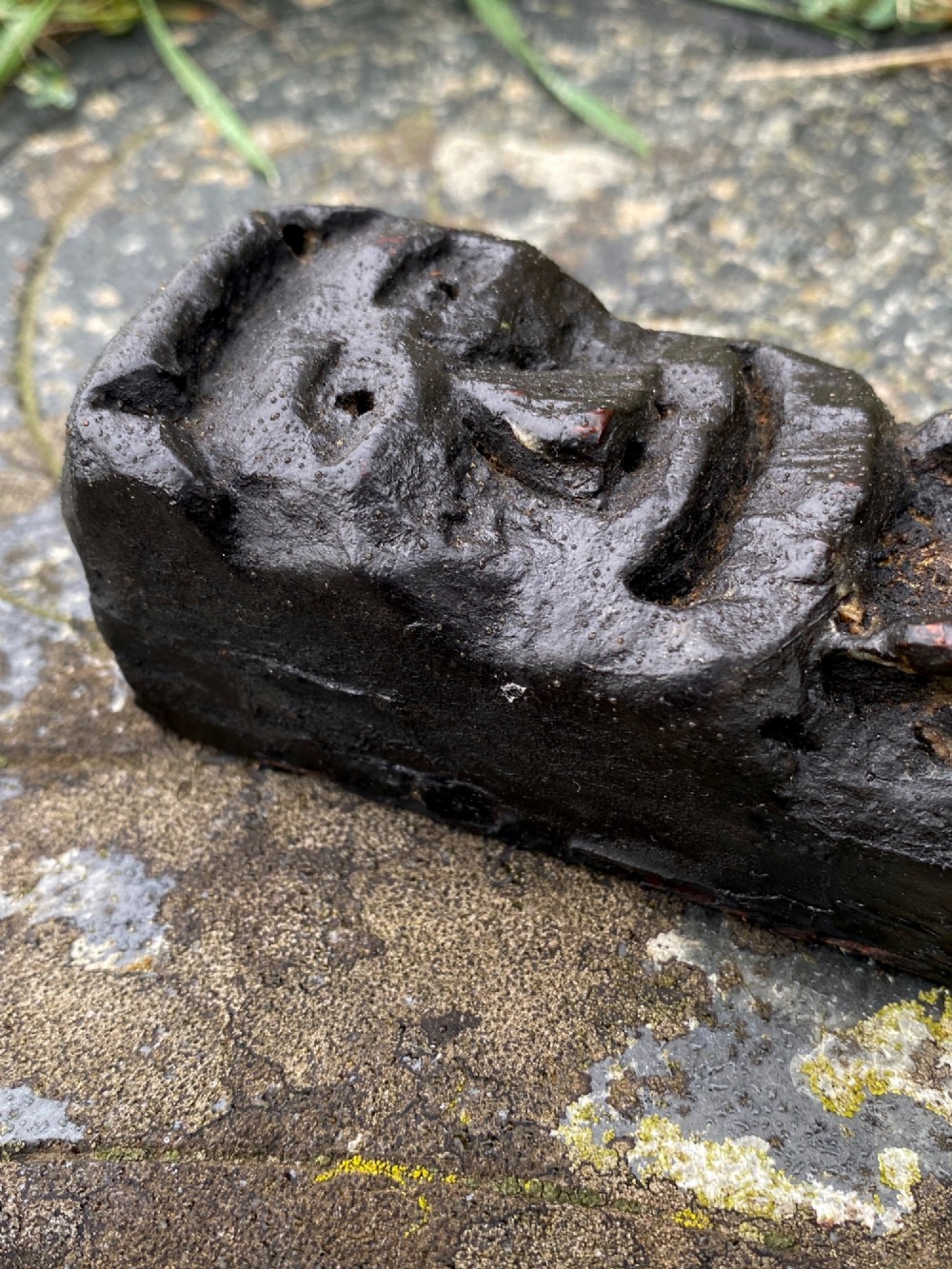 A vertical dark oak wood carving depicting a stylised human face and figure with hand-chiselled detailing. View IV