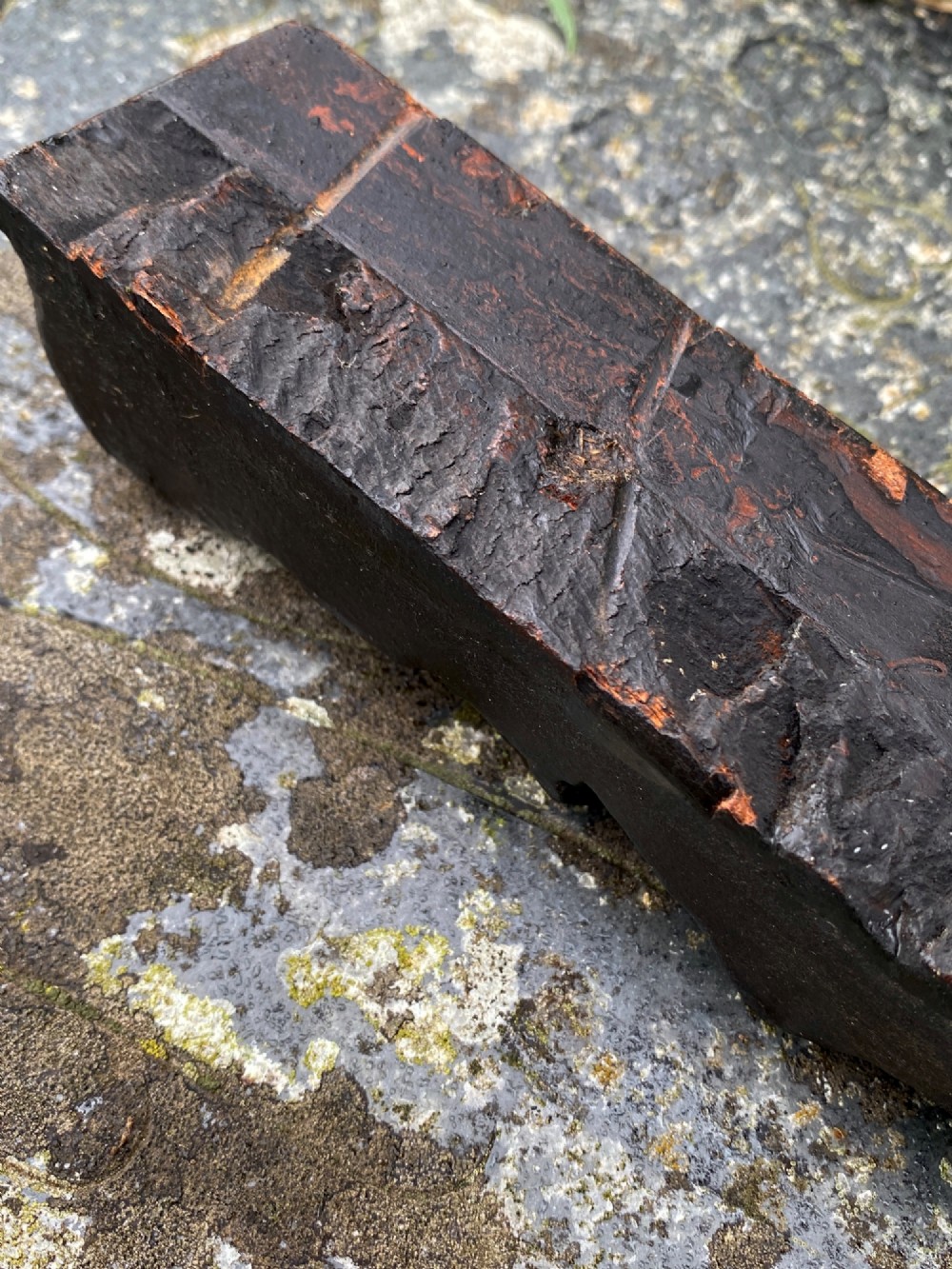 A vertical dark oak wood carving depicting a stylised human face and figure with hand-chiselled detailing. View X