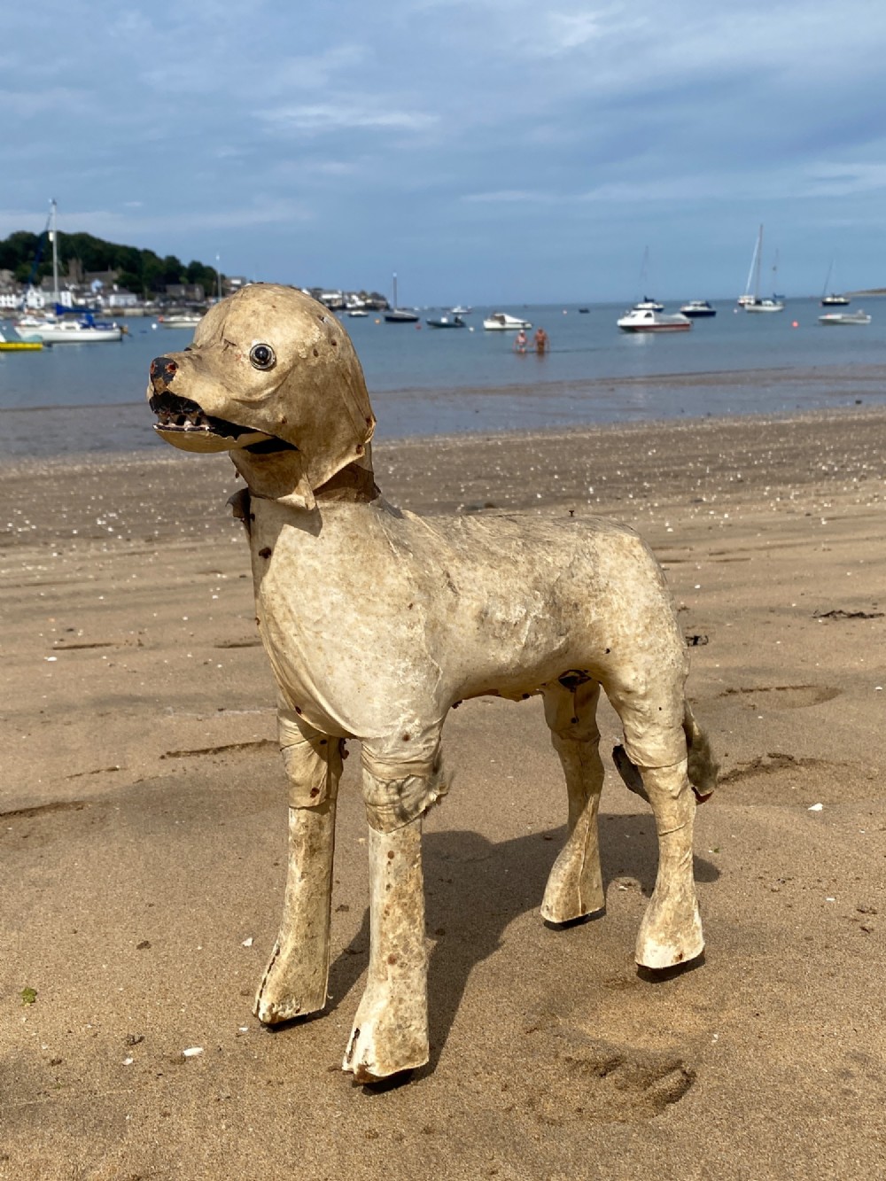 An early twentieth-century folk art dog head sculpture constructed from aged parchment leather with glass eyes and a movable mouth revealing painted teeth. View III