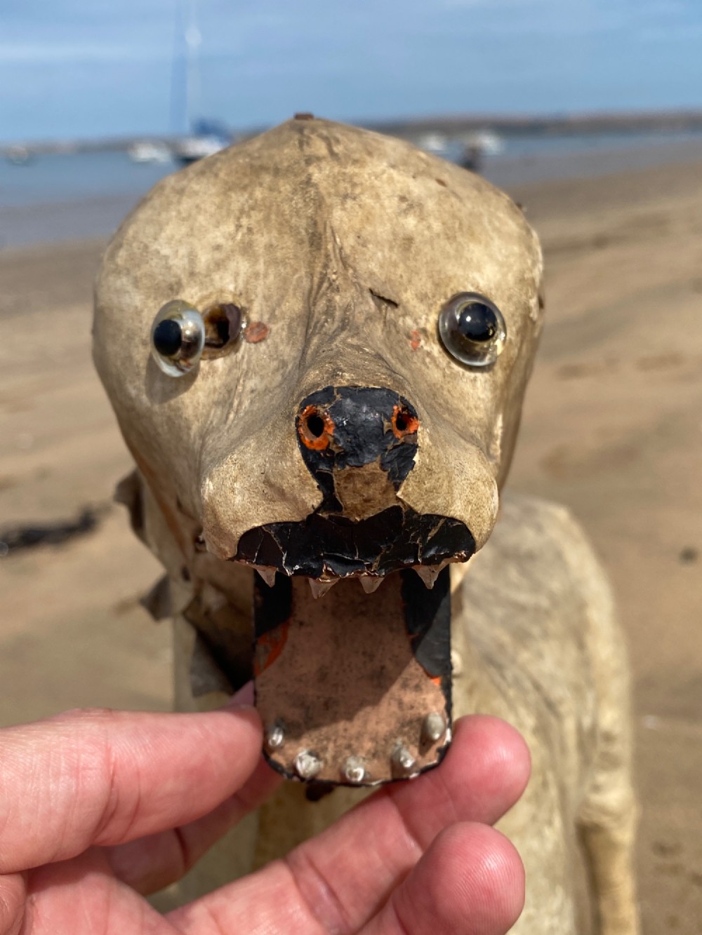 An early twentieth-century folk art dog head sculpture constructed from aged parchment leather with glass eyes and a movable mouth revealing painted teeth. View XI