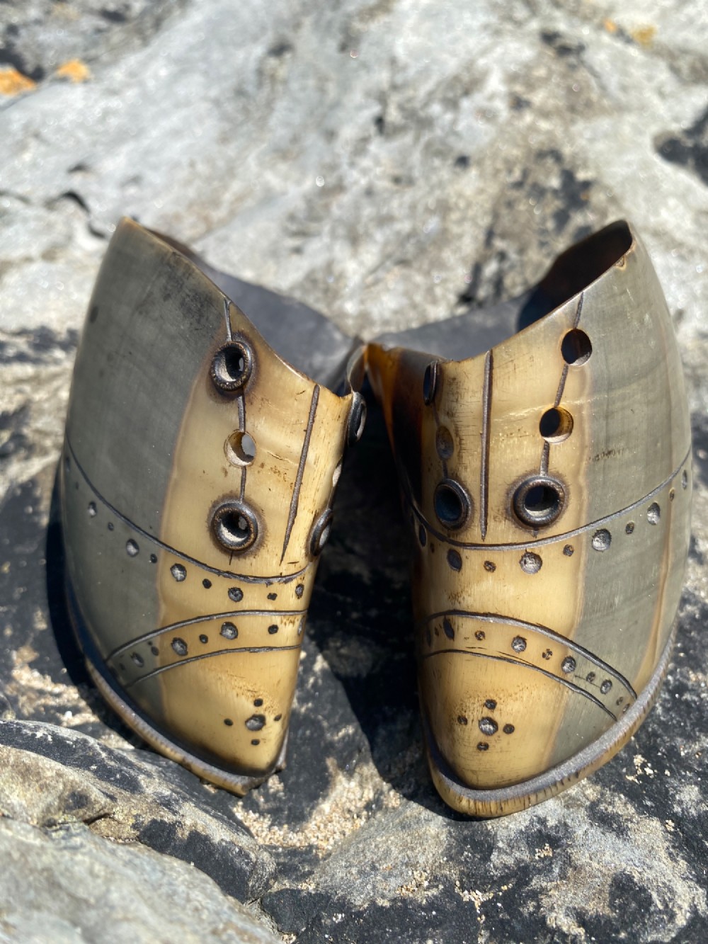 A pair of 19th-century folk art miniature shoes crafted from horn with incised shoe details and punched eyelets. View VI