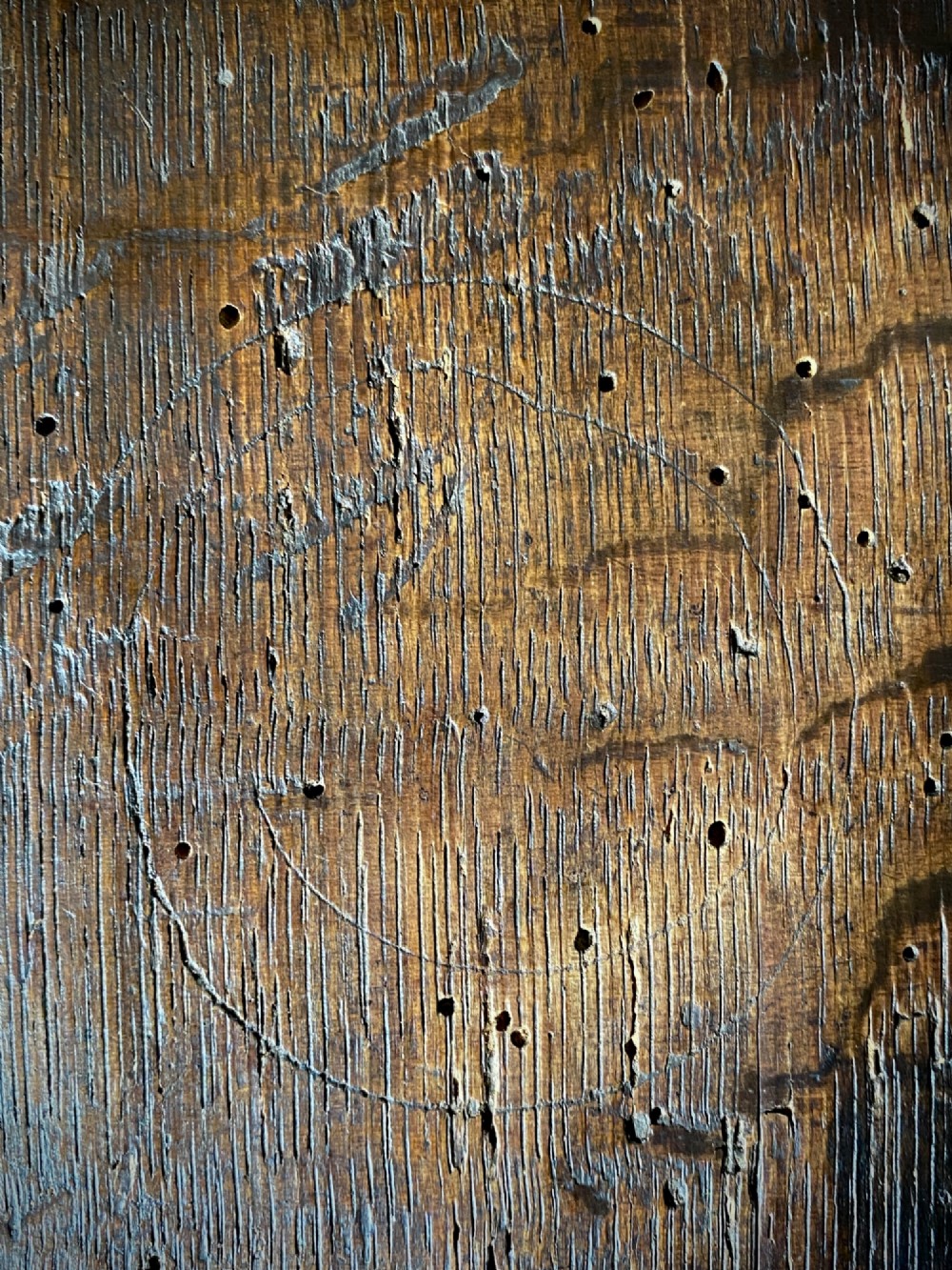 A carved dark oak panel featuring a repetitive geometric foliage pattern beside a detailed close-up of incised concentric circles and ritual marks on the wood grain. View III