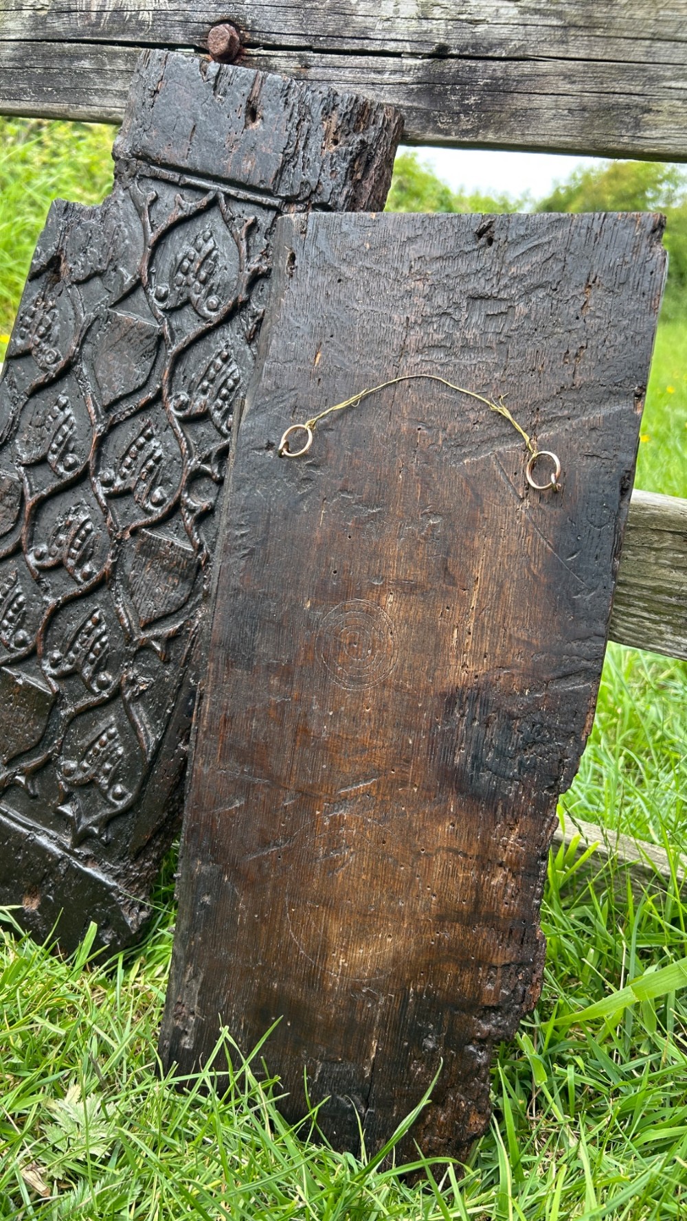 A carved dark oak panel featuring a repetitive geometric foliage pattern beside a detailed close-up of incised concentric circles and ritual marks on the wood grain. View XII