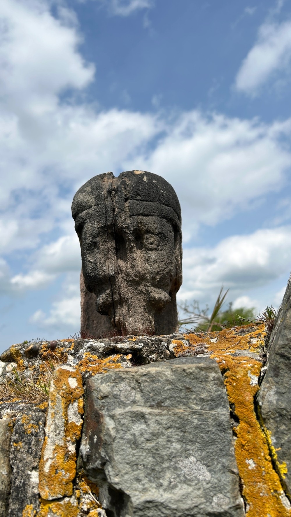 A weathered 17th-century carved stone head fragment with defined facial features and visible surface erosion. View II