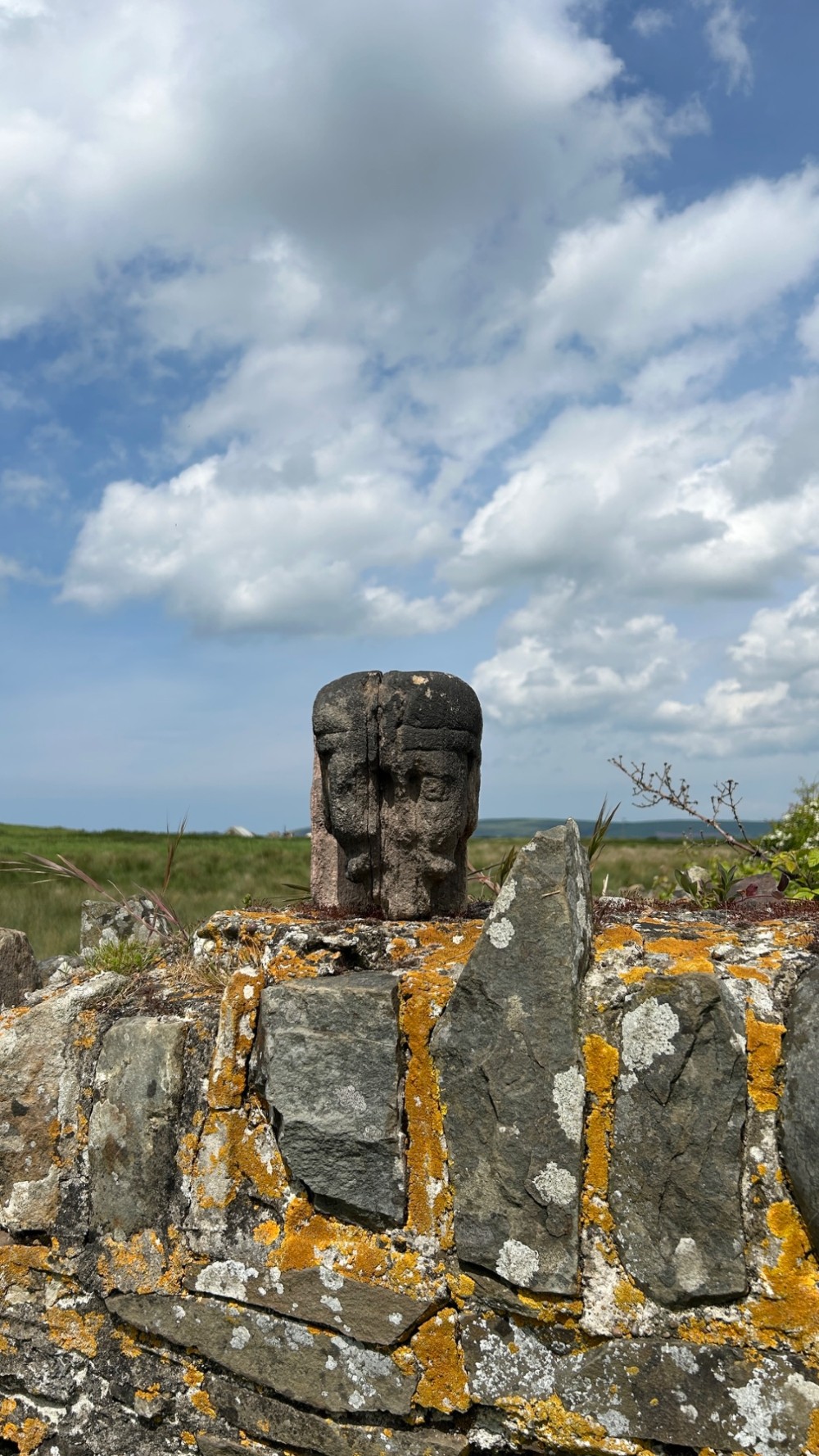 A weathered 17th-century carved stone head fragment with defined facial features and visible surface erosion. View VIII