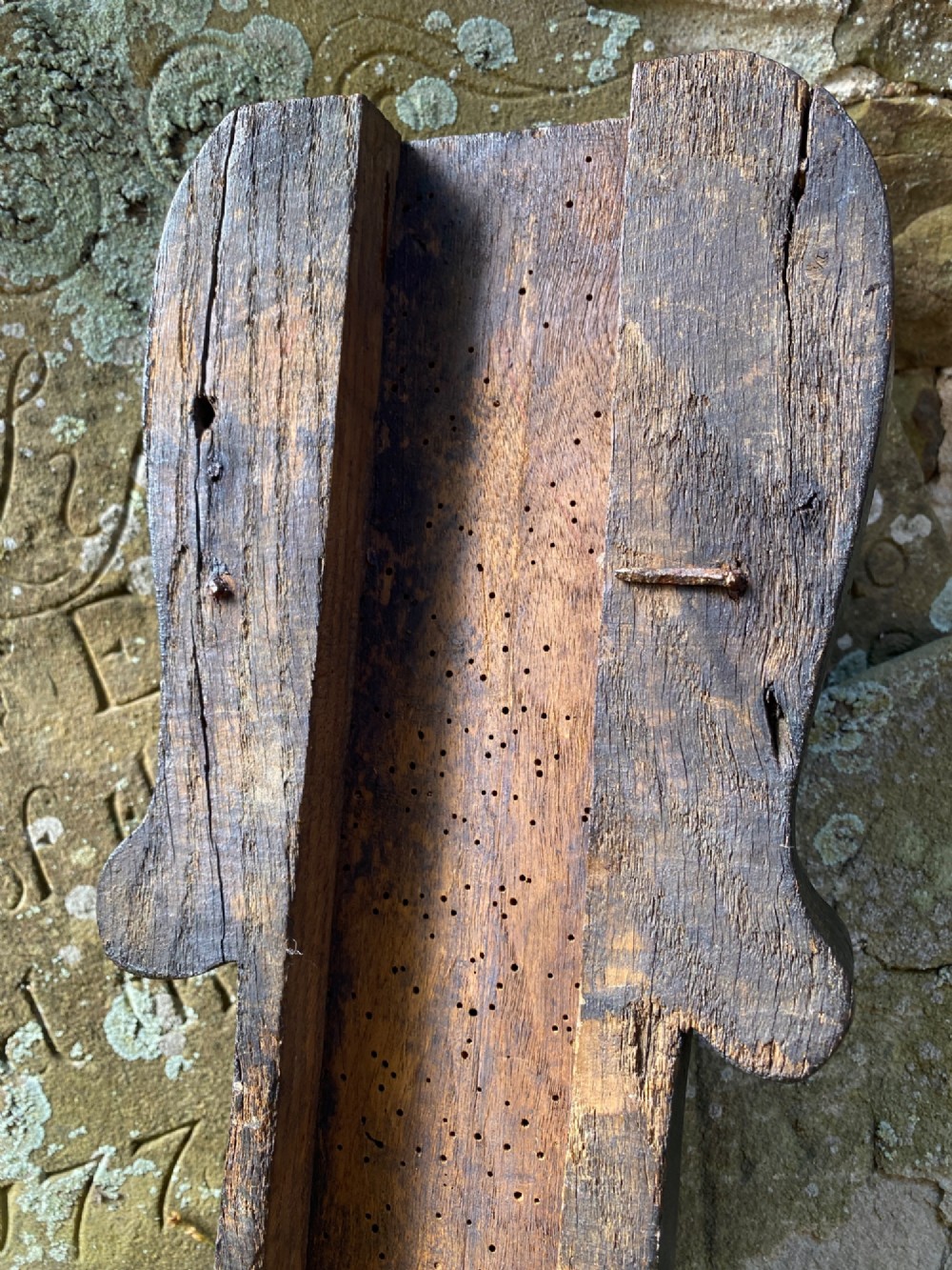 A hand-carved dark oak wood element featuring a stylised Green Man face tapering down into a lion paw base. View VIII