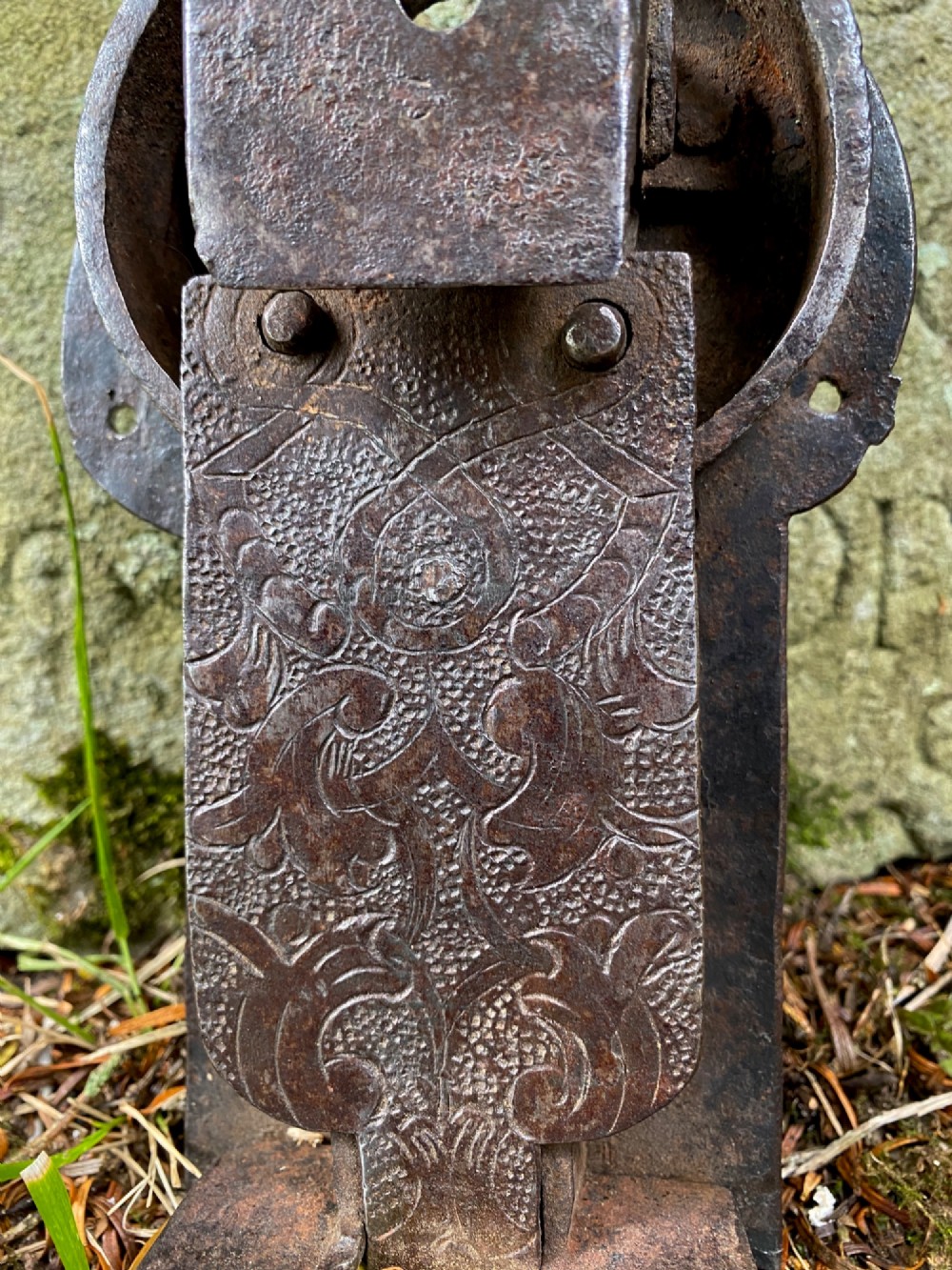 A hand-forged dark wrought iron lock plate featuring a trefoil crest, projecting key pipe, and surface oxidisation. View IV