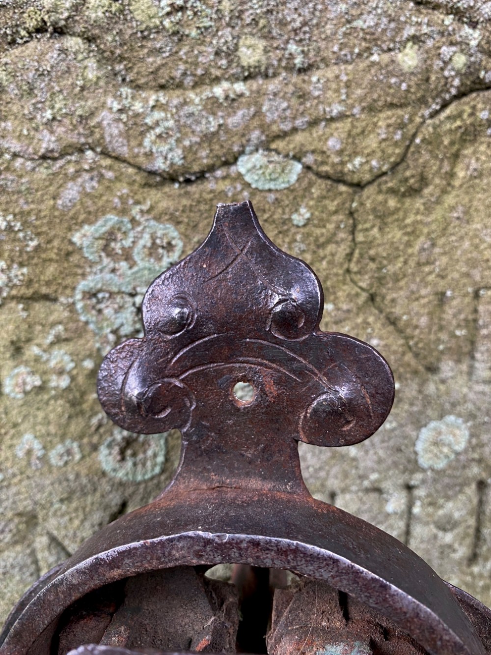 A hand-forged dark wrought iron lock plate featuring a trefoil crest, projecting key pipe, and surface oxidisation. View VI