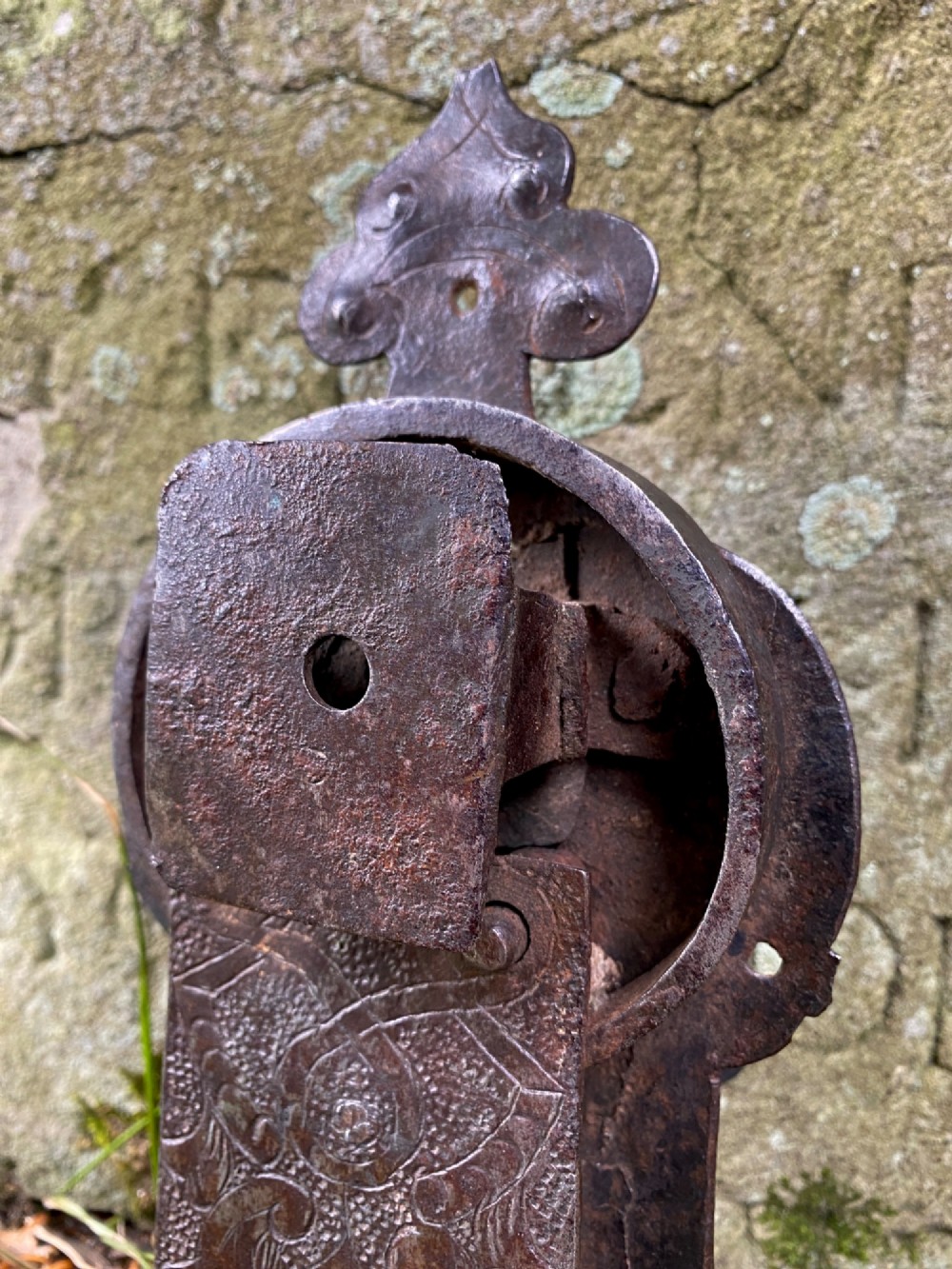 A hand-forged dark wrought iron lock plate featuring a trefoil crest, projecting key pipe, and surface oxidisation. View VIII