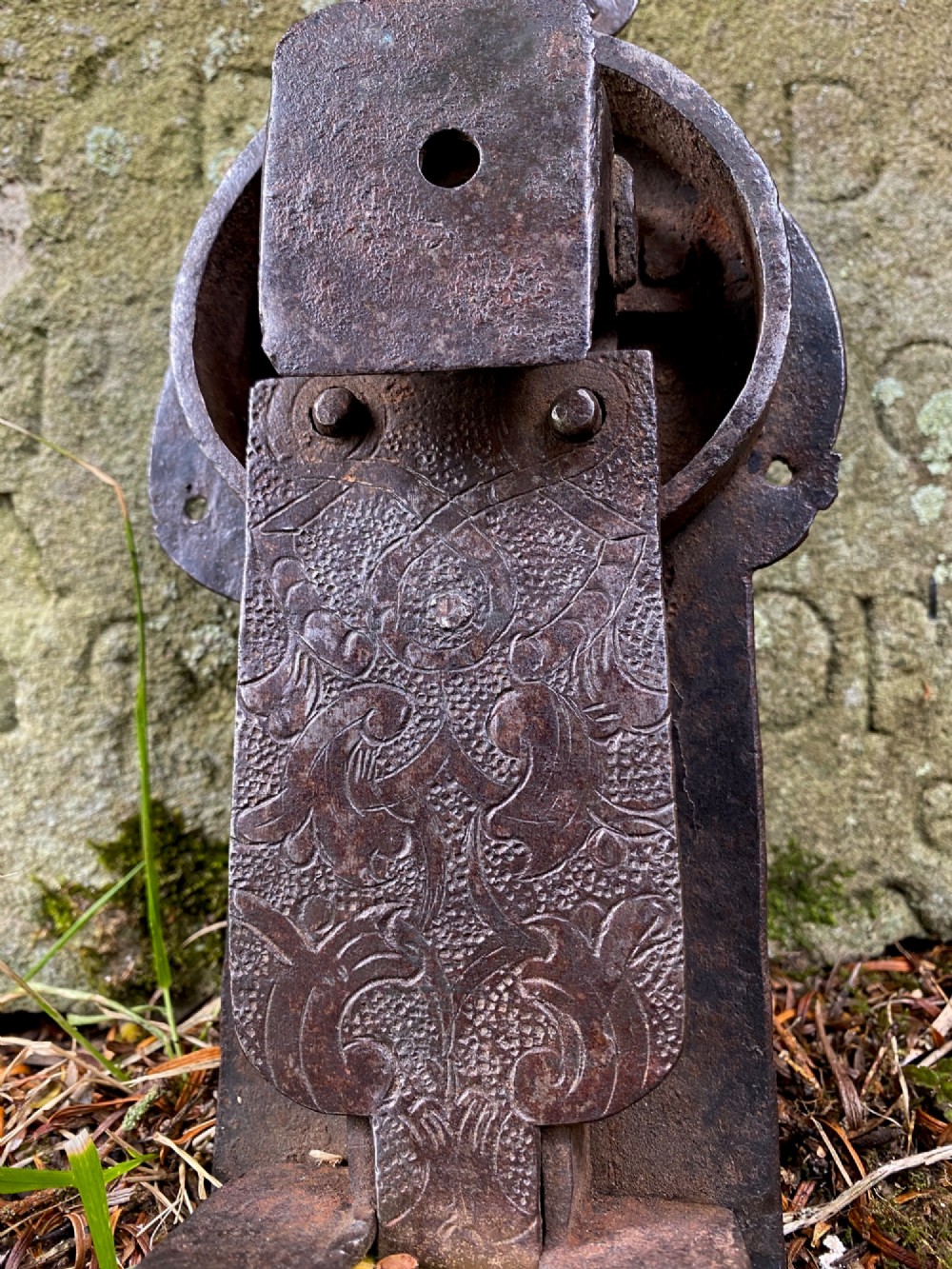 A hand-forged dark wrought iron lock plate featuring a trefoil crest, projecting key pipe, and surface oxidisation. View IX