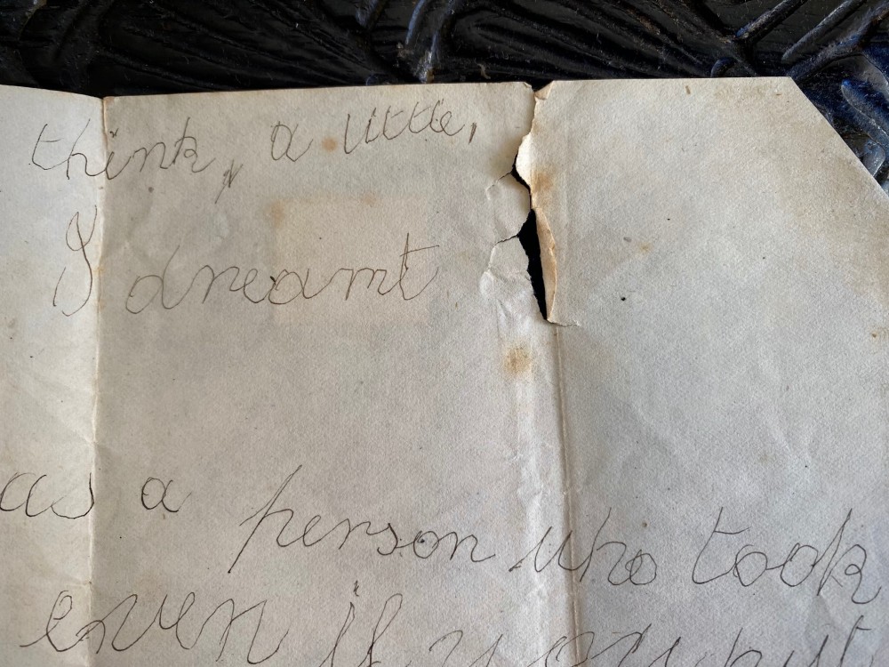 A folded 19th-century handwritten letter on creased cream paper with cursive script and a red Queen Victoria halfpenny postage stamp. View VI