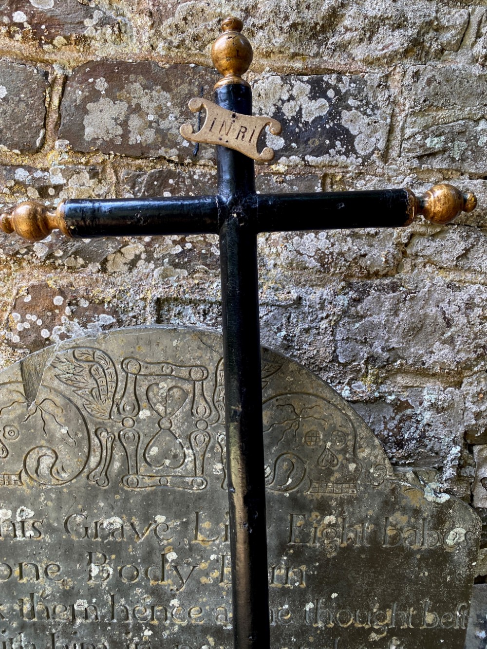 An 18th-century ebonised wooden cross with giltwood finials and an INRI scroll set upon a mould-shaped stepped base. View II