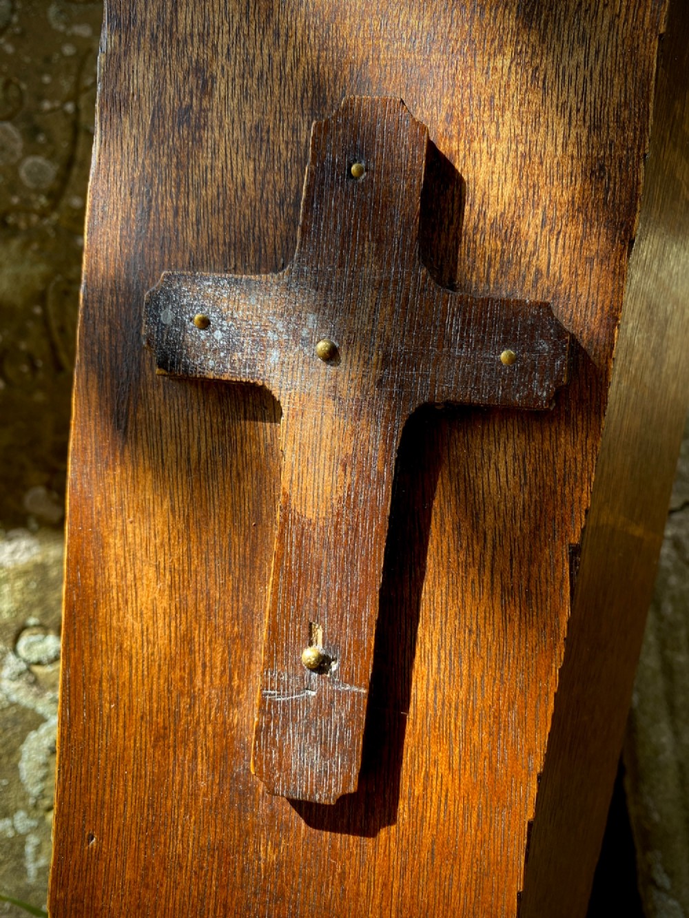A wooden coffin-shaped collection box featuring a raised wooden cross motif and a narrow coin slot on the front lid. View VII