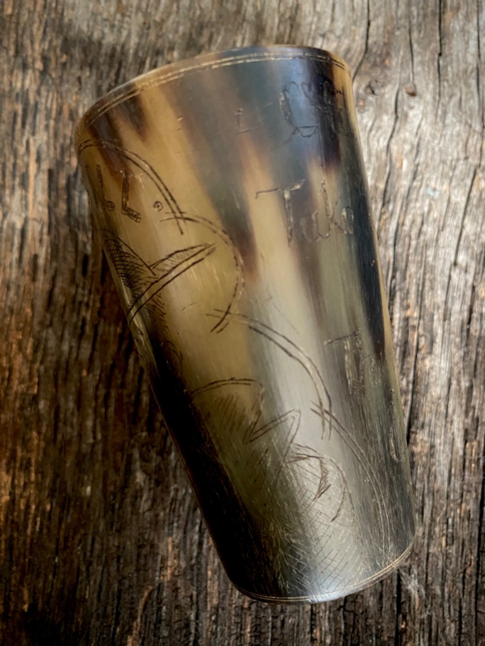 A translucent natural horn beaker featuring a detailed line engraving of the Bruce Bairnsfather character Old Bill wearing a helmet. View V