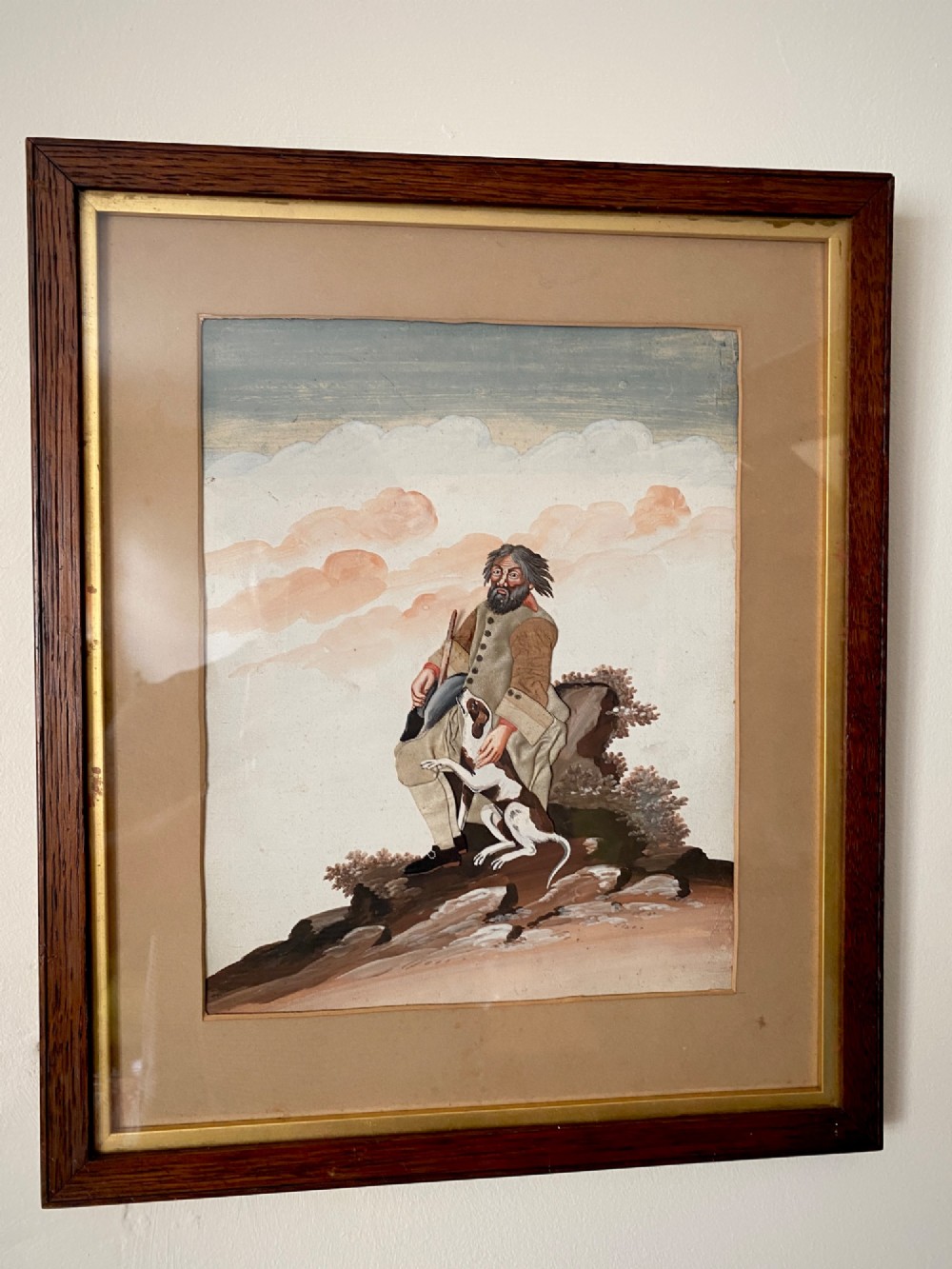A late 18th-century Georgian folk art picture depicting a seated gamekeeper in fabric attire resting his hand on a spotted dog. View II