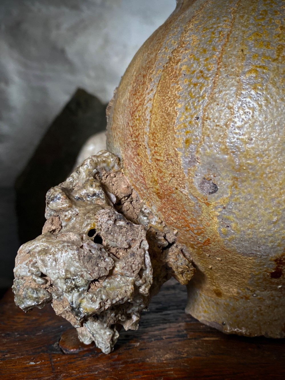 A salt-glazed stoneware Bartmann jug featuring a moulded bearded face mask on the neck and a round medallion crest on the globular body. View II