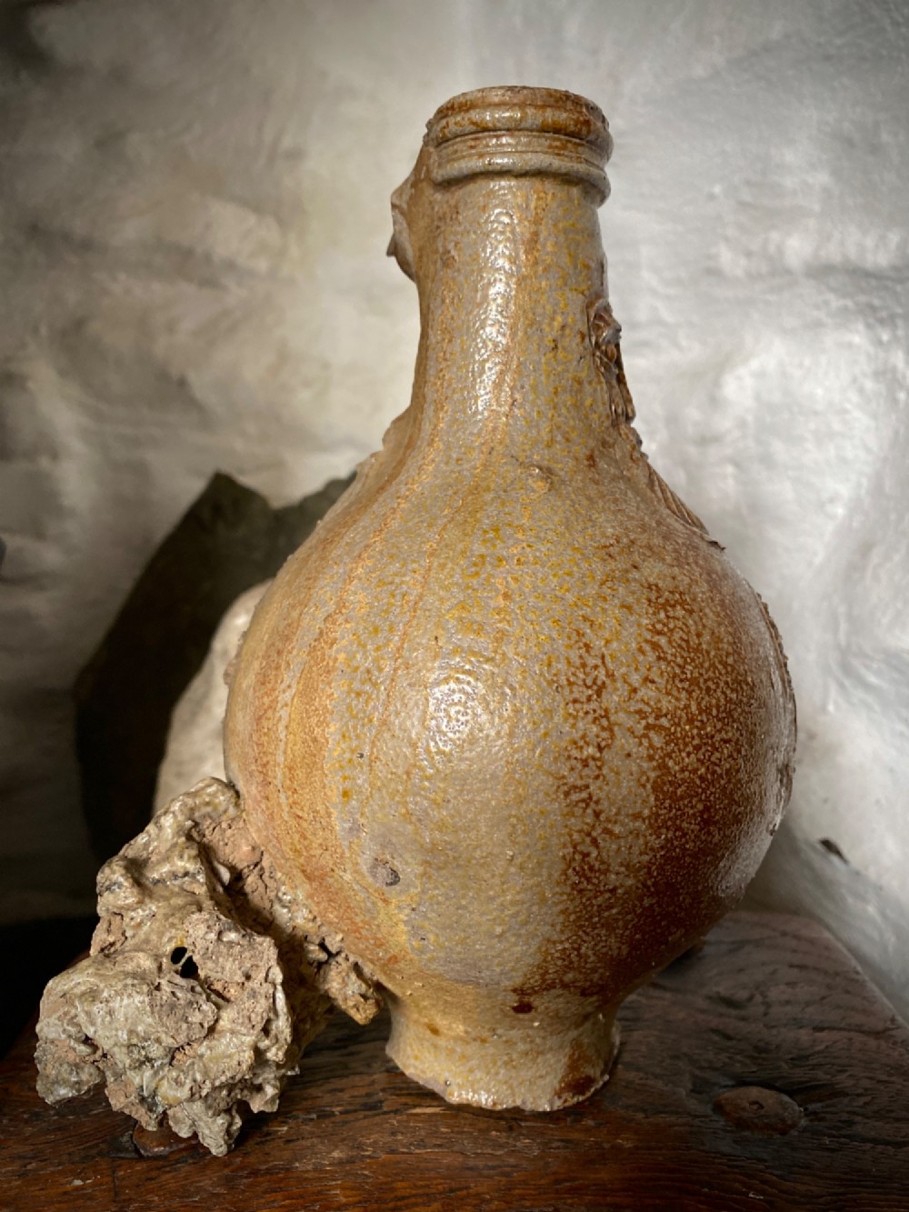 A salt-glazed stoneware Bartmann jug featuring a moulded bearded face mask on the neck and a round medallion crest on the globular body. View IV