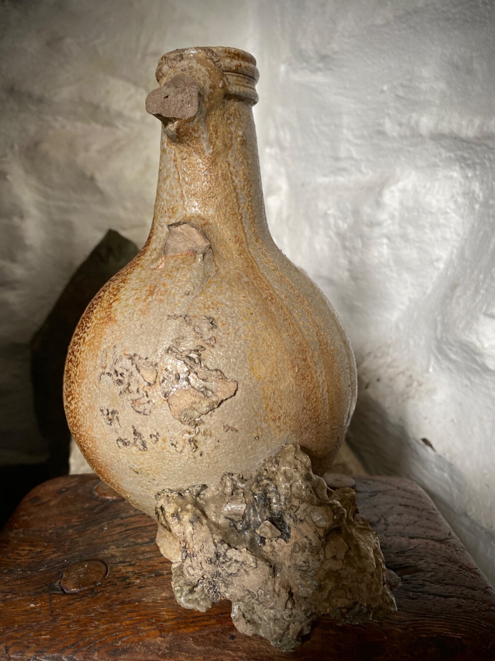 A salt-glazed stoneware Bartmann jug featuring a moulded bearded face mask on the neck and a round medallion crest on the globular body. View VI