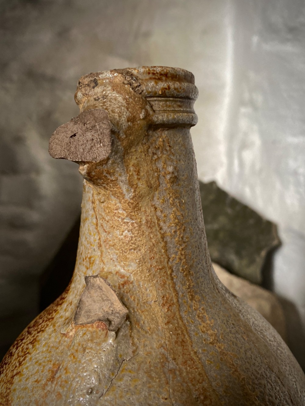 A salt-glazed stoneware Bartmann jug featuring a moulded bearded face mask on the neck and a round medallion crest on the globular body. View VIII