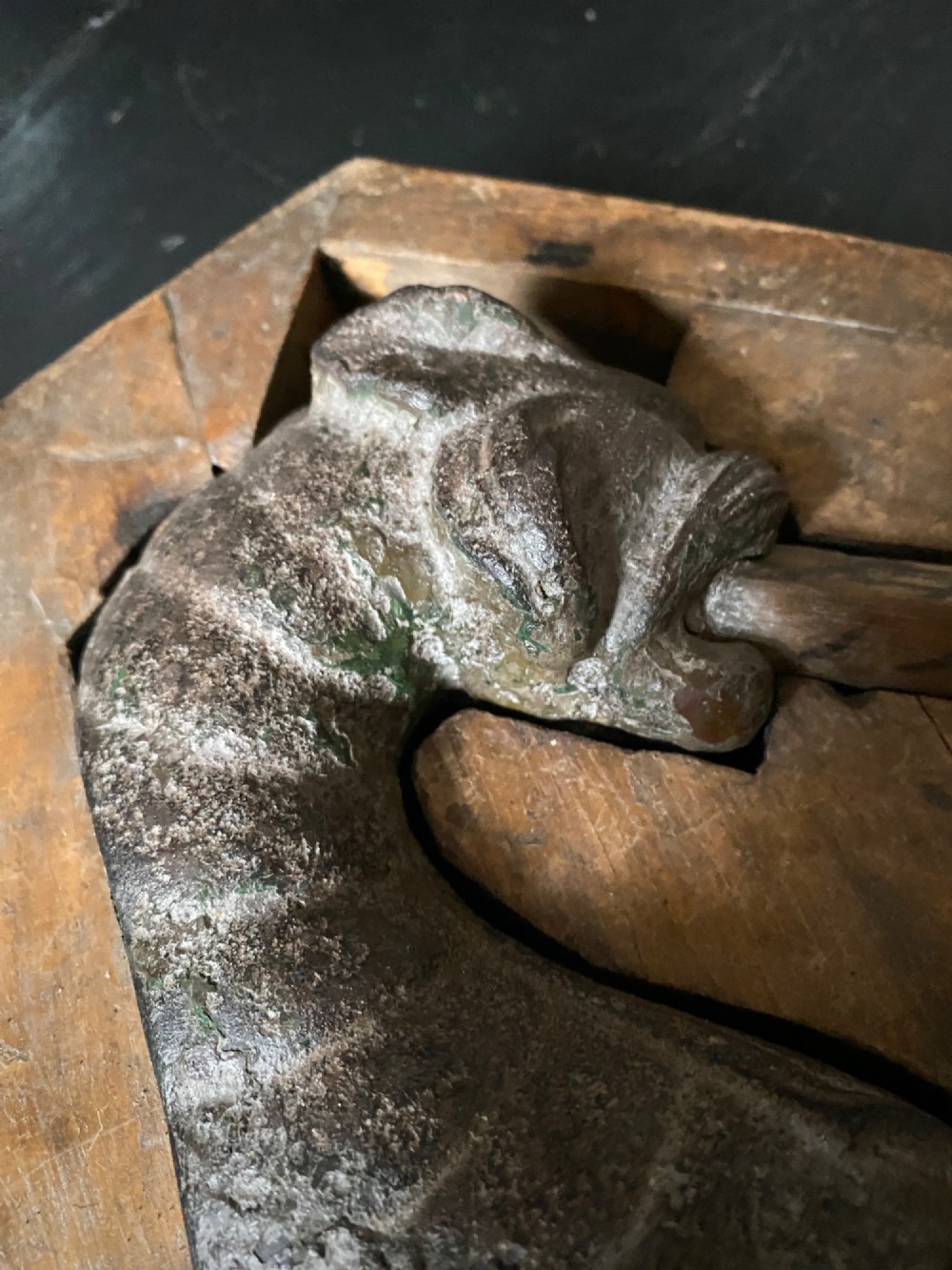 A three-piece set of carved wooden pattern moulds featuring a central seated gargoyle figure flanked by two bat-like wing panels with red paint accents. View IV