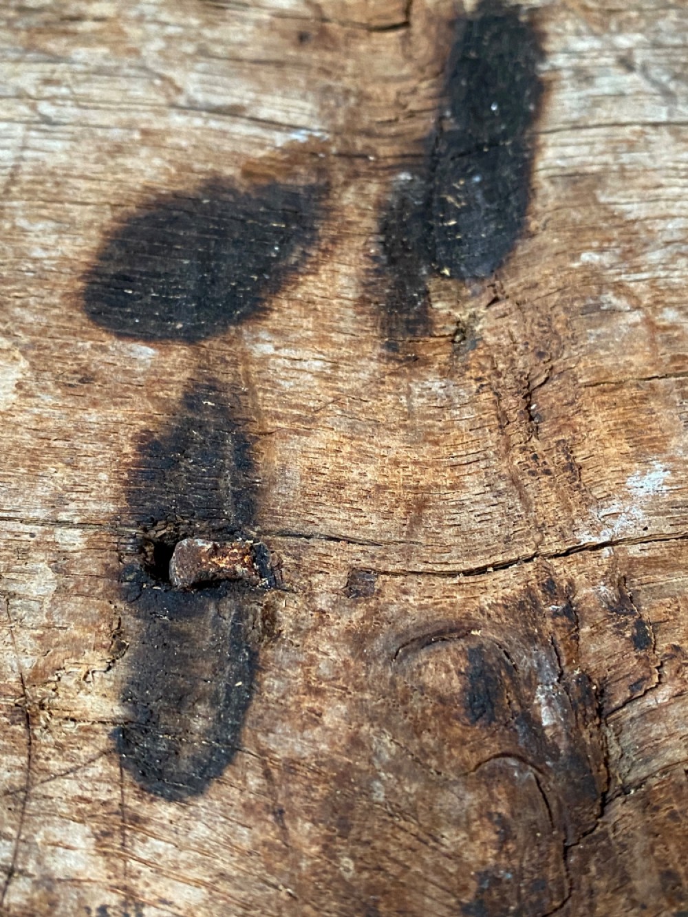 A tall, hand-hewn 17th-century solid oak beam featuring multiple dark apotropaic taper burn marks along its weathered wood surface. View VI