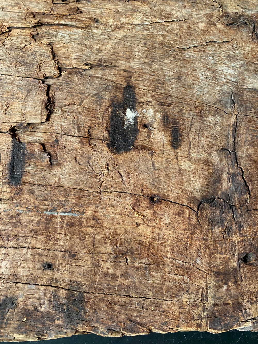 A tall, hand-hewn 17th-century solid oak beam featuring multiple dark apotropaic taper burn marks along its weathered wood surface. View XI