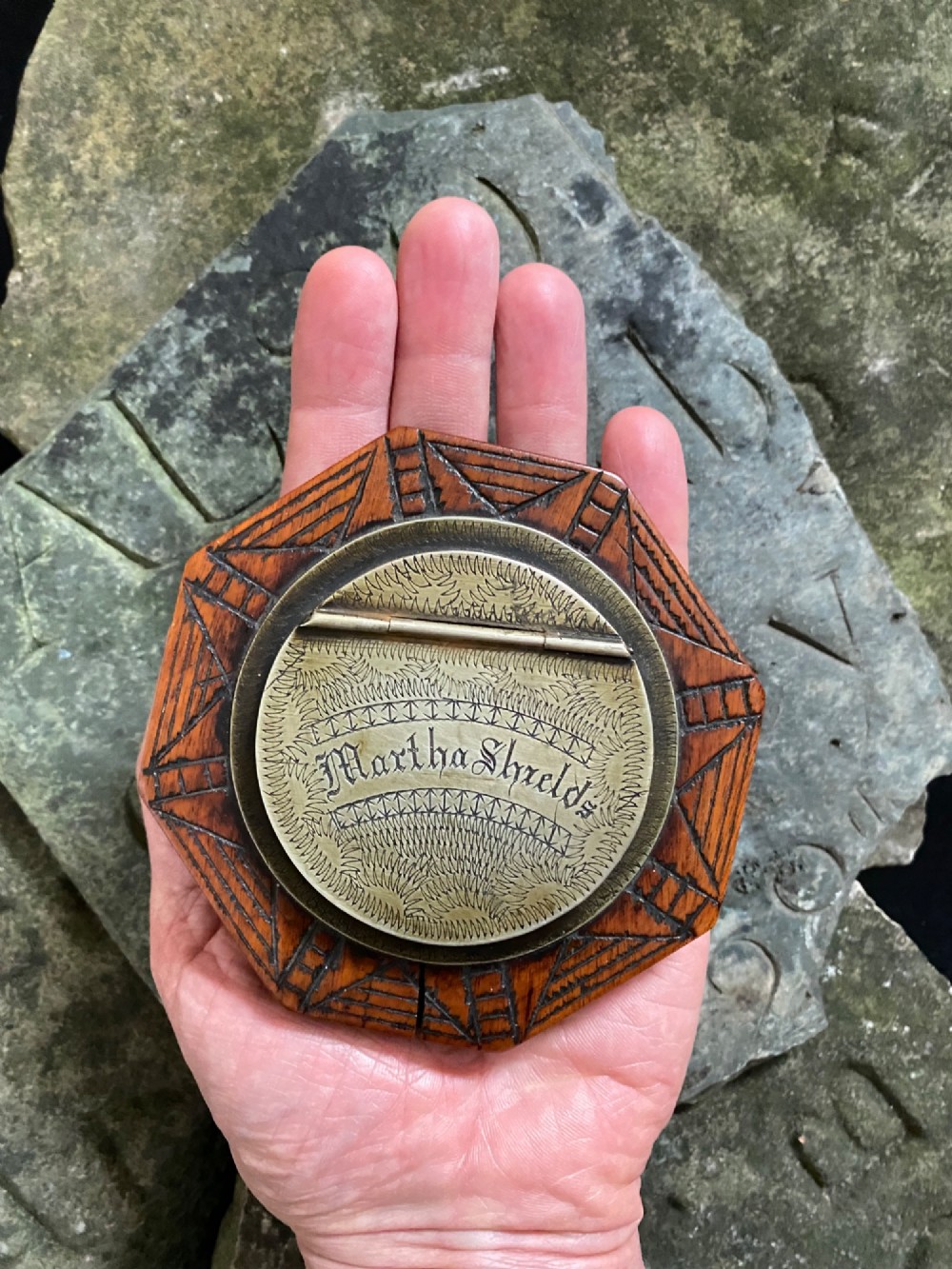 An early nineteenth-century octagonal carved wooden treen snuff box featuring an engraved brass hinged lid inscribed with the name Martha Shields.