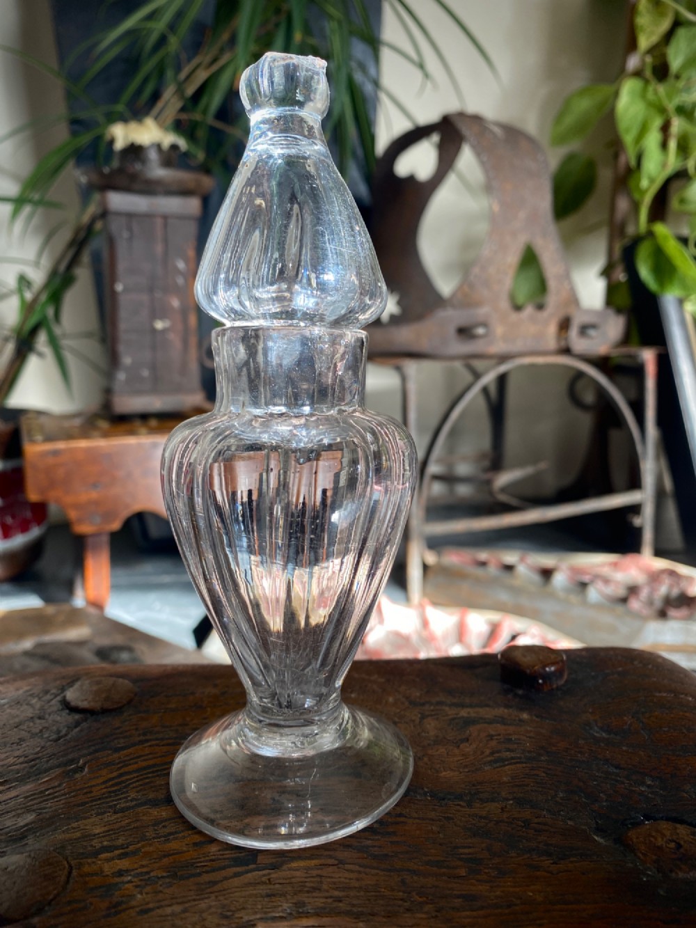 An 18th-century clear hand-blown glass dry mustard jar featuring vertical fluting, a circular footed base, and a removable pointed glass stopper.