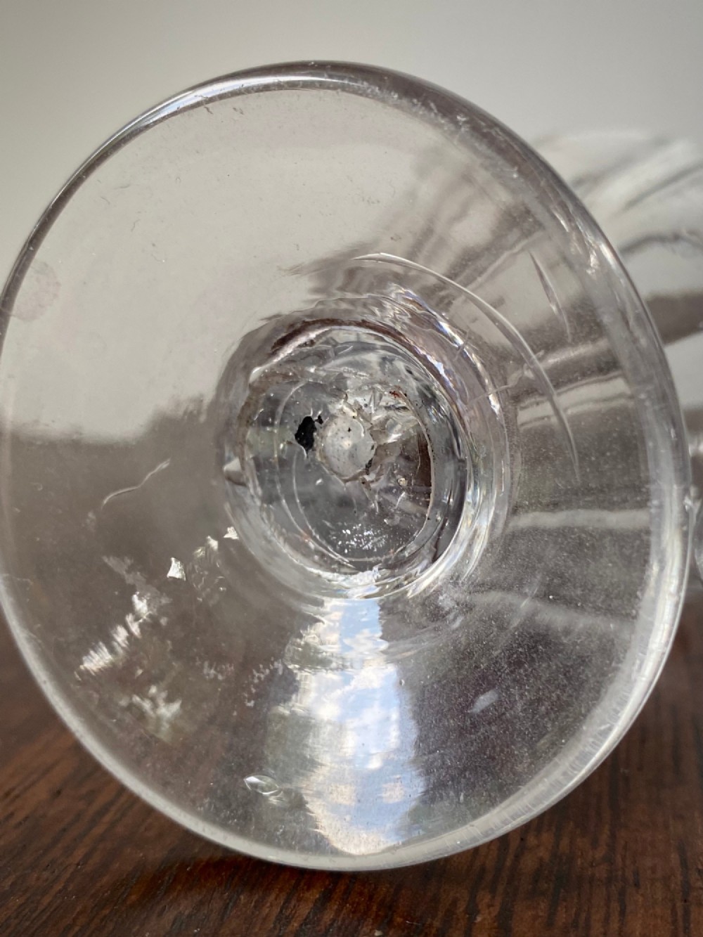 An 18th-century clear hand-blown glass dry mustard jar featuring vertical fluting, a circular footed base, and a removable pointed glass stopper. View VI
