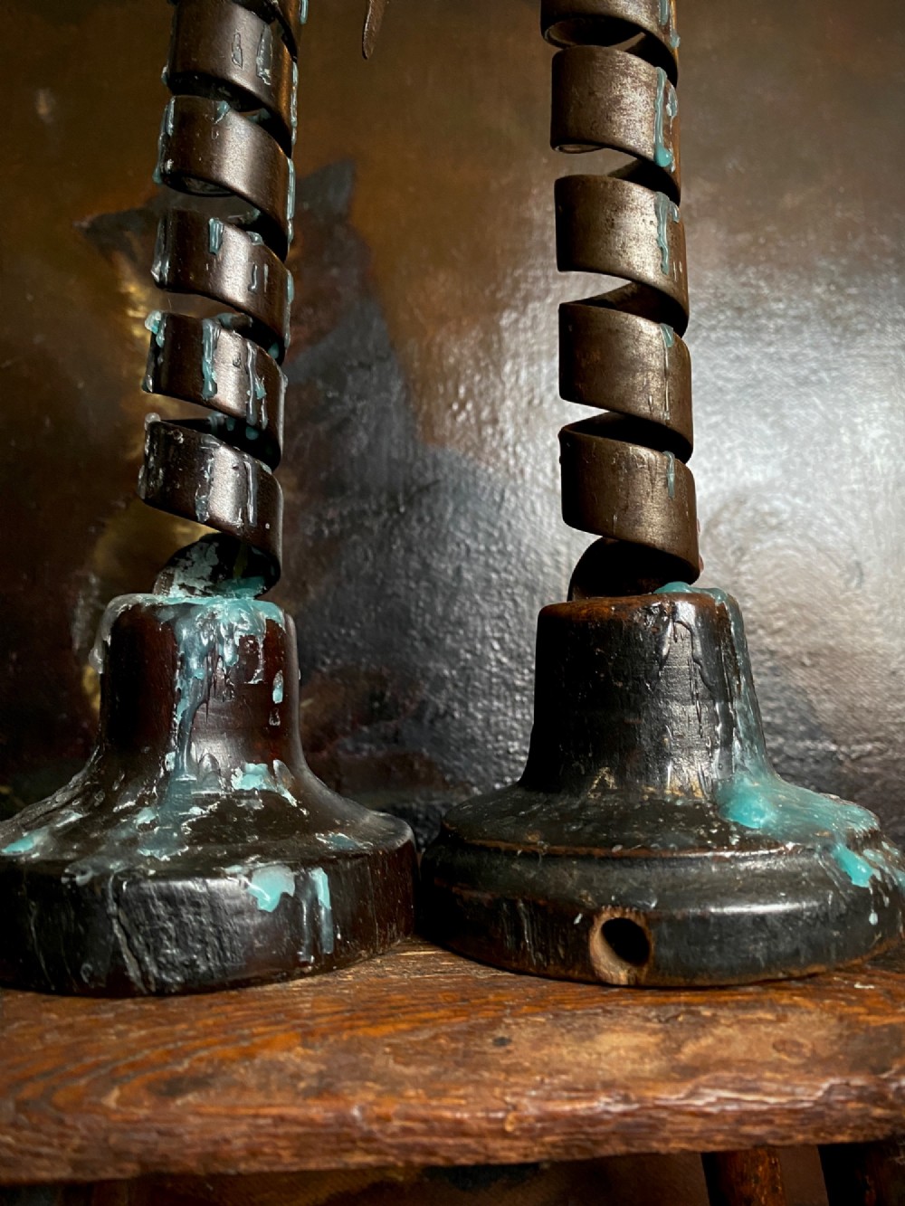 A pair of antique wrought iron spiral candlesticks with hooked handles set into turned dark wood bases. View IV