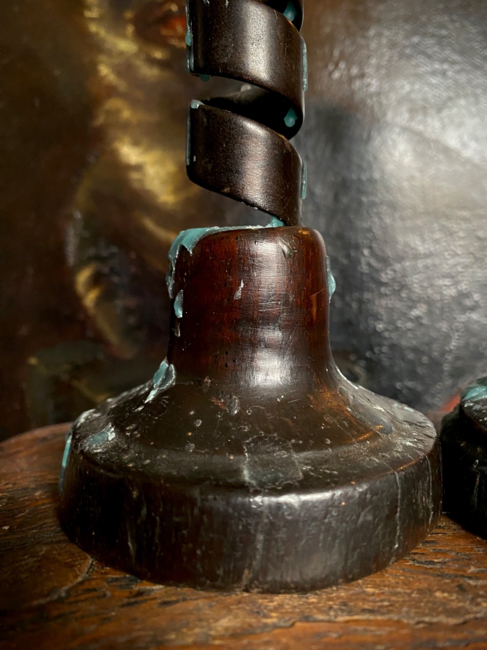 A pair of antique wrought iron spiral candlesticks with hooked handles set into turned dark wood bases. View V