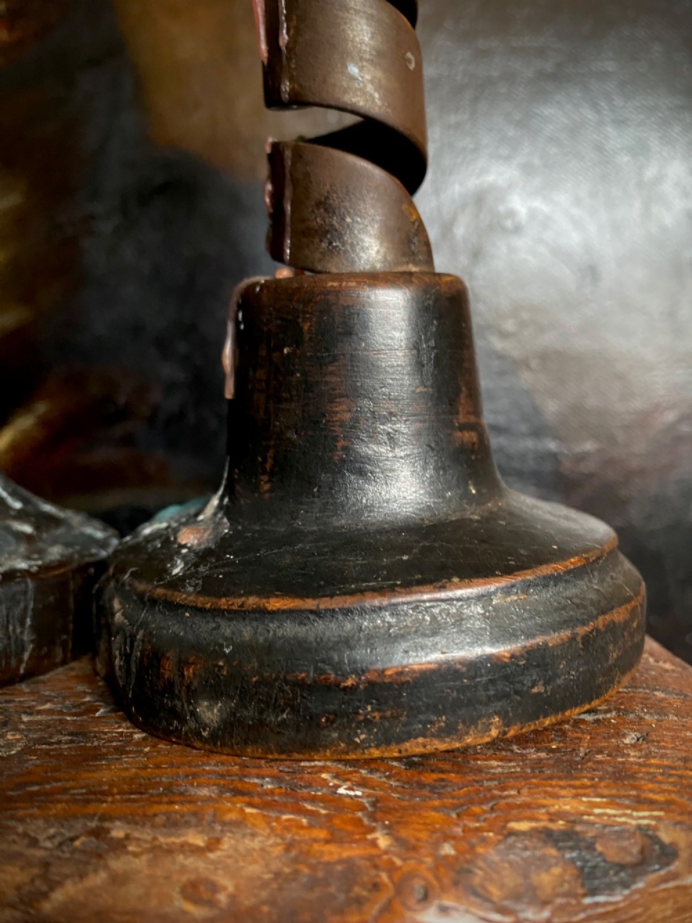 A pair of antique wrought iron spiral candlesticks with hooked handles set into turned dark wood bases. View VII