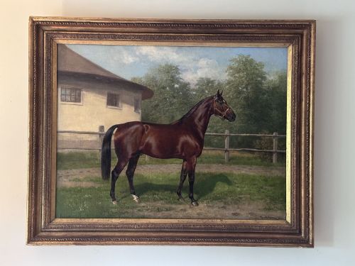 fig 1. An antique oil painting depicting a bay horse standing in profile wearing a leather bridle in an outdoor paddock in front of a circular building.