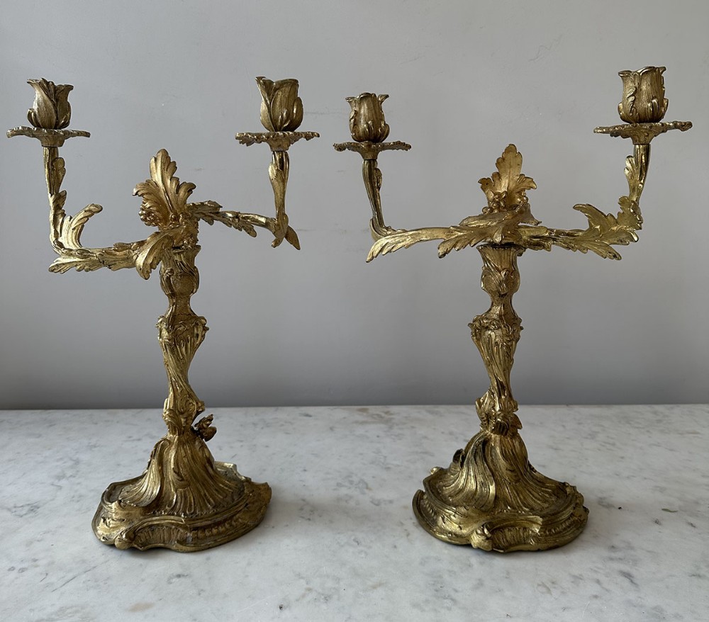 A pair of nineteenth-century French Rococo revival gilt bronze candelabras featuring two curving leaf-form arms and floral sconces.