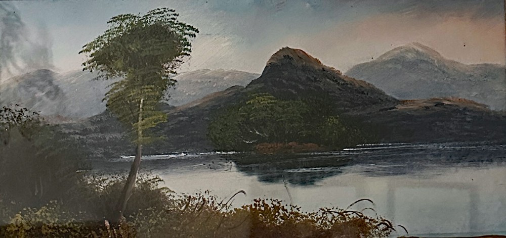 An antique panoramic oil painting depicting a calm lake framed by distant mountains under a cloudy sky with foliage in the foreground.