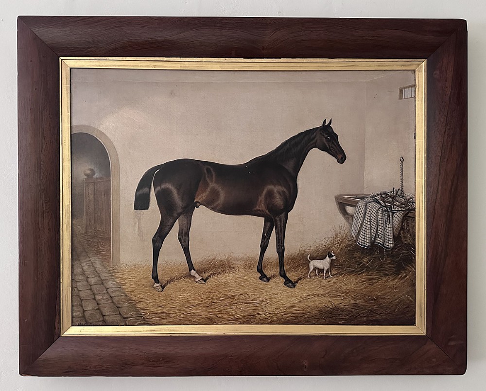 An antique oil painting depicting a dark bay horse standing inside a stable alongside a small terrier dog. View II