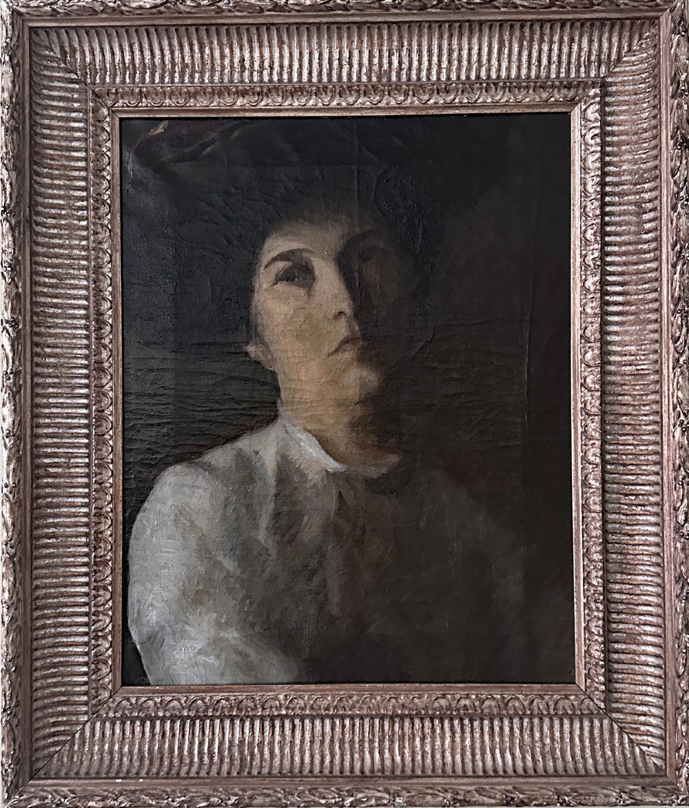 An antique oil painting on canvas depicting a woman wearing a dark hat and light-coloured blouse in low-light illumination. View II