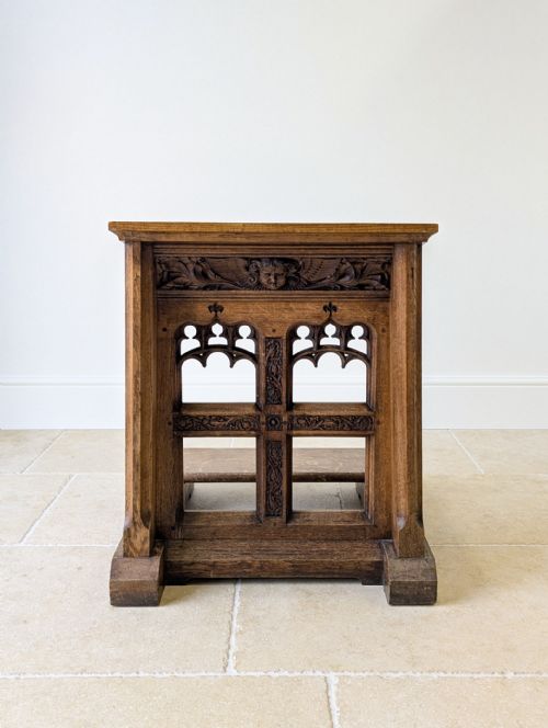 fig 1. A Victorian Gothic Revival oak prie-dieu featuring carved tracery arches, a central cross motif, a cherub frieze, and a low kneeling step.