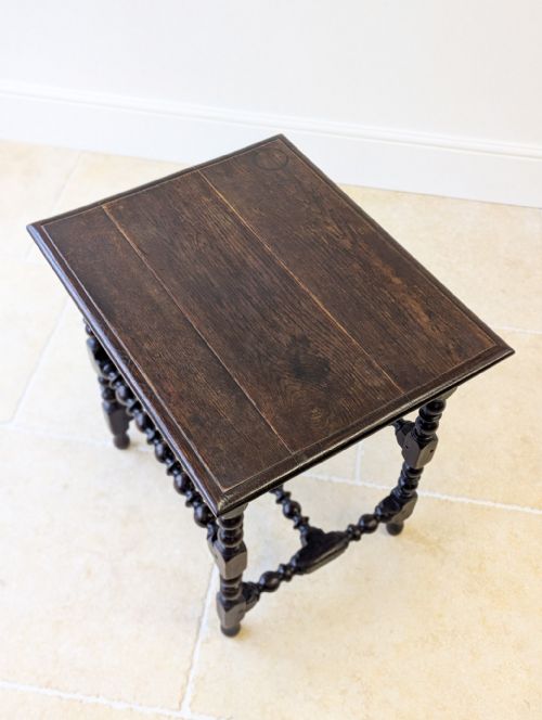 fig 1. A seventeenth-century dark oak side table with bobbin-turned legs and lower stretchers beneath a rectangular flat top.