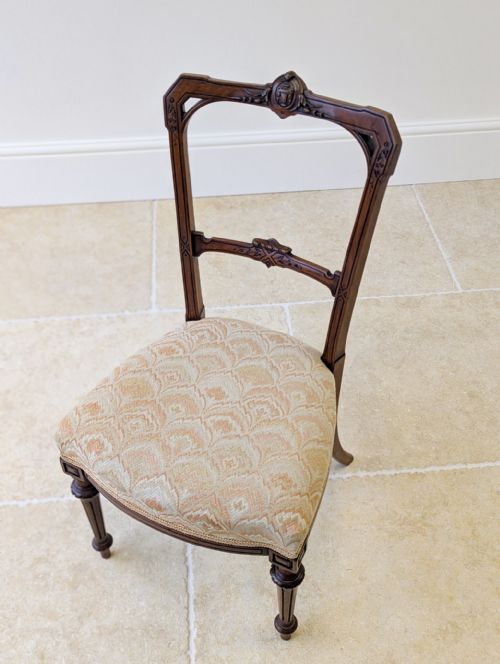 fig 2. A set of three late nineteenth-century Victorian Neoclassical mahogany salon chairs featuring carved crest rails, open backrests, patterned upholstered seats, and fluted front legs.