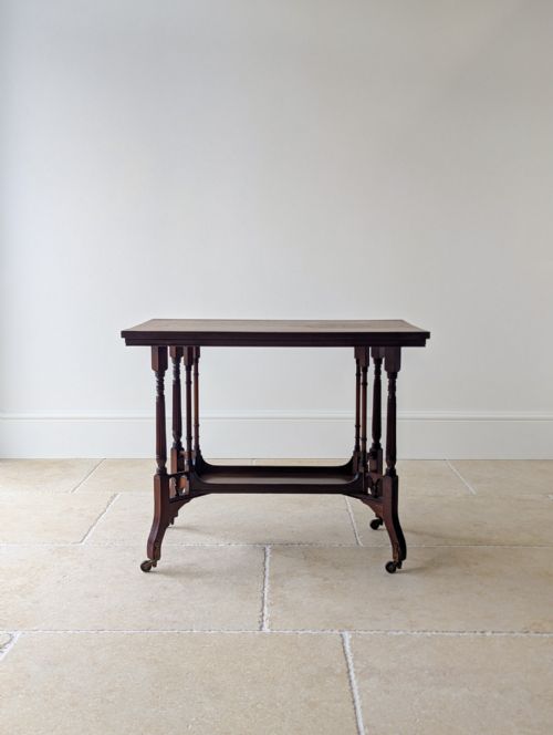 fig 1. A dark mahogany rectangular side table featuring fluted turned legs, a lower shelf tier, and brass castors.