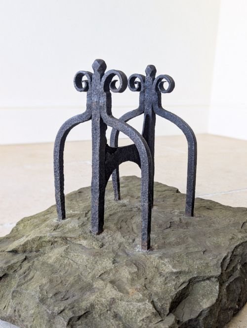 fig 1. A Georgian wrought iron boot scraper featuring twin decorative scrolled uprights mounted onto a rough-hewn rectangular Yorkstone base.